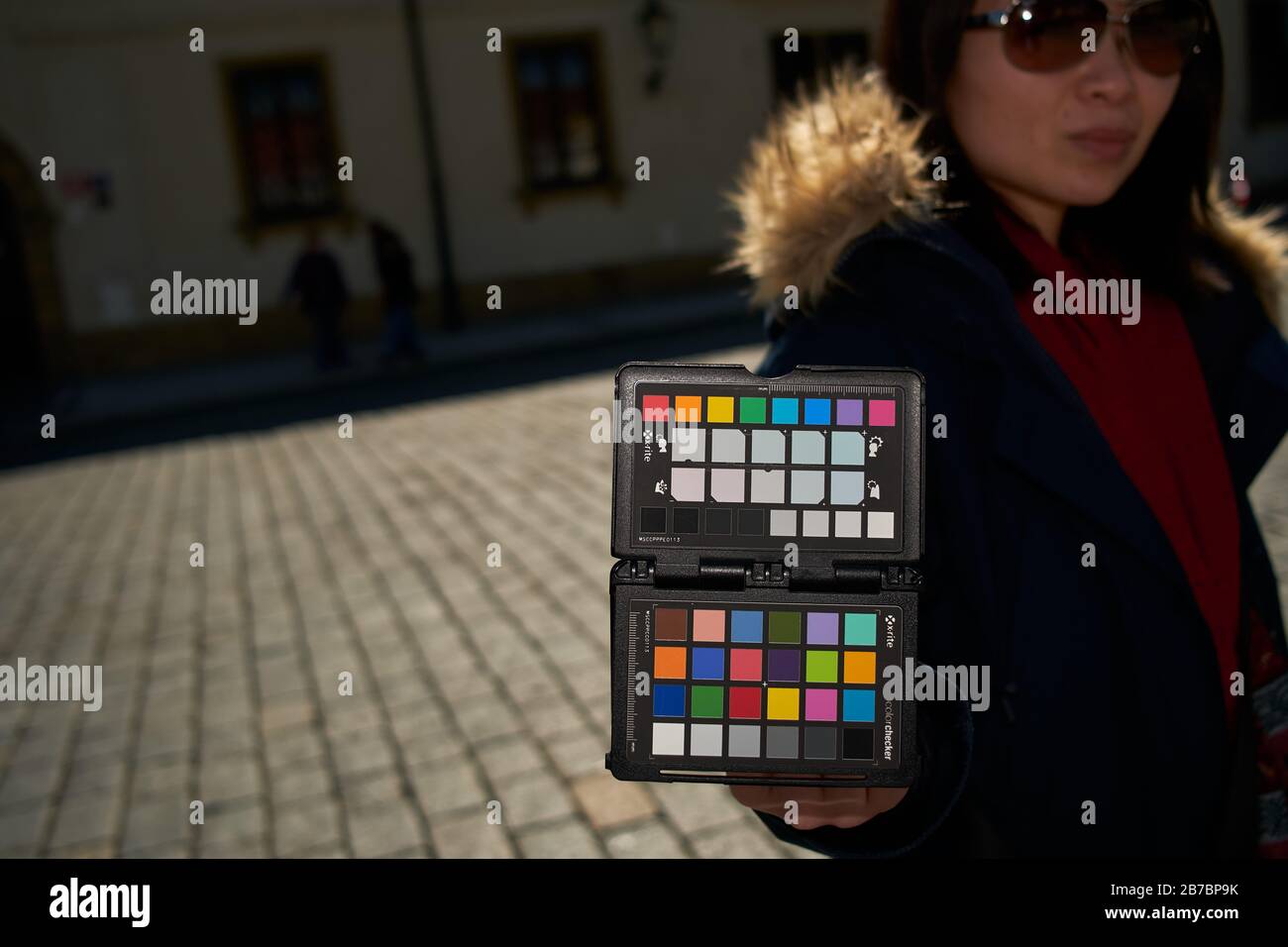 Woman holding X-rite colorchecker passport on location for camera white balance and color calibration photo Stock Photo