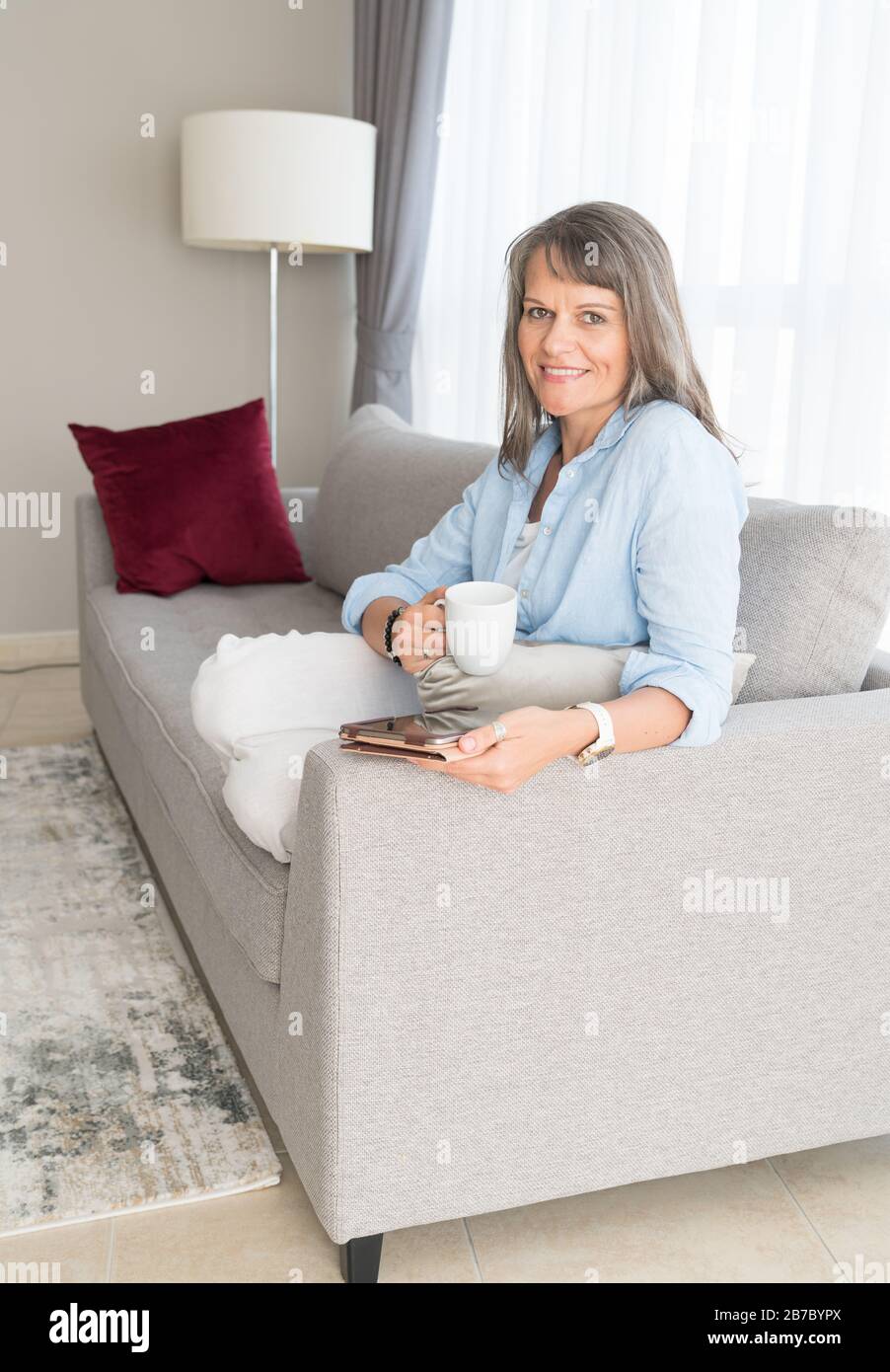 Attractive mature woman on sofa hi-res stock photography and images - Alamy