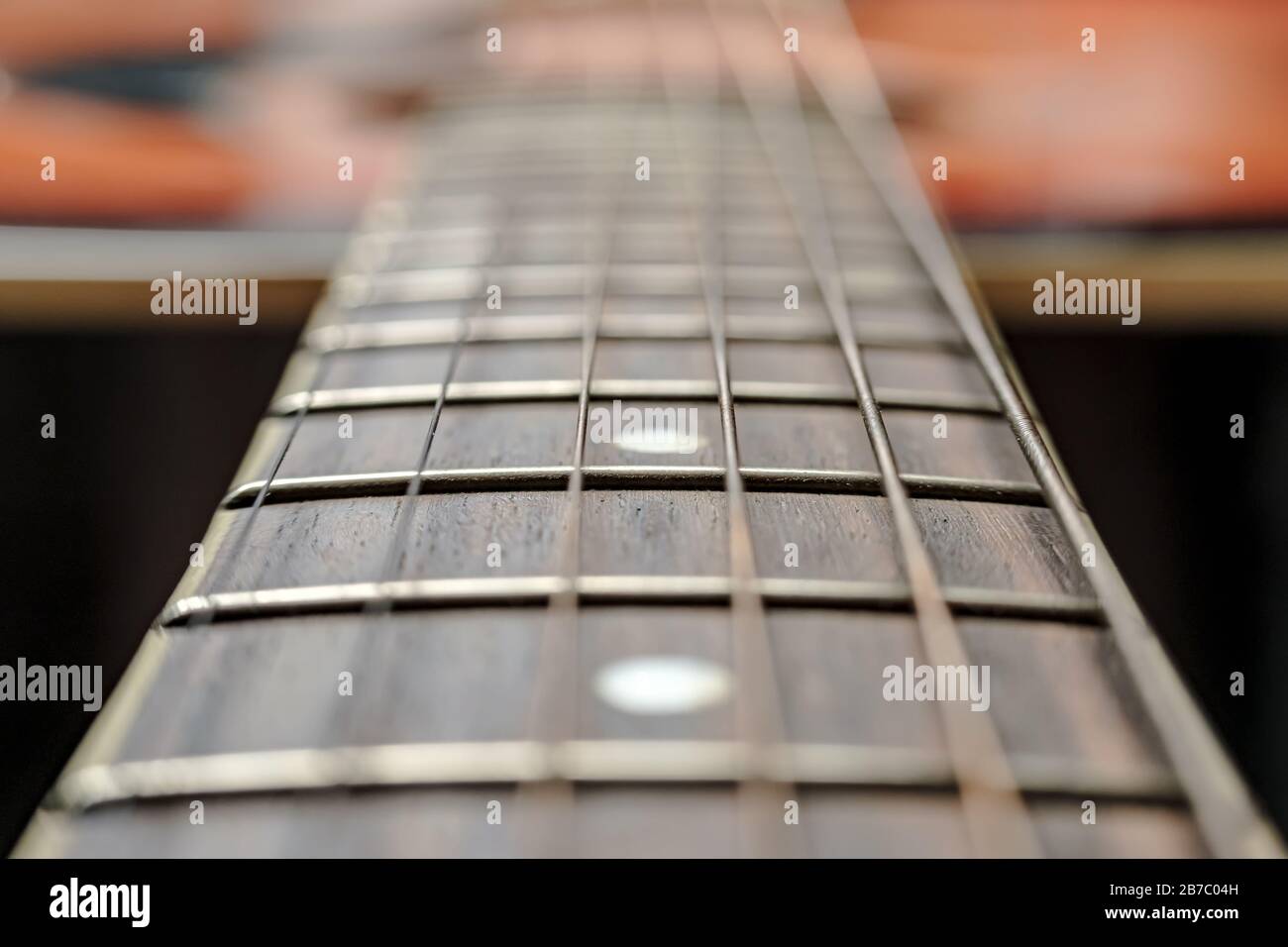 Neck with strings, close-up, on an old, classic acoustic guitar. Stock Photo