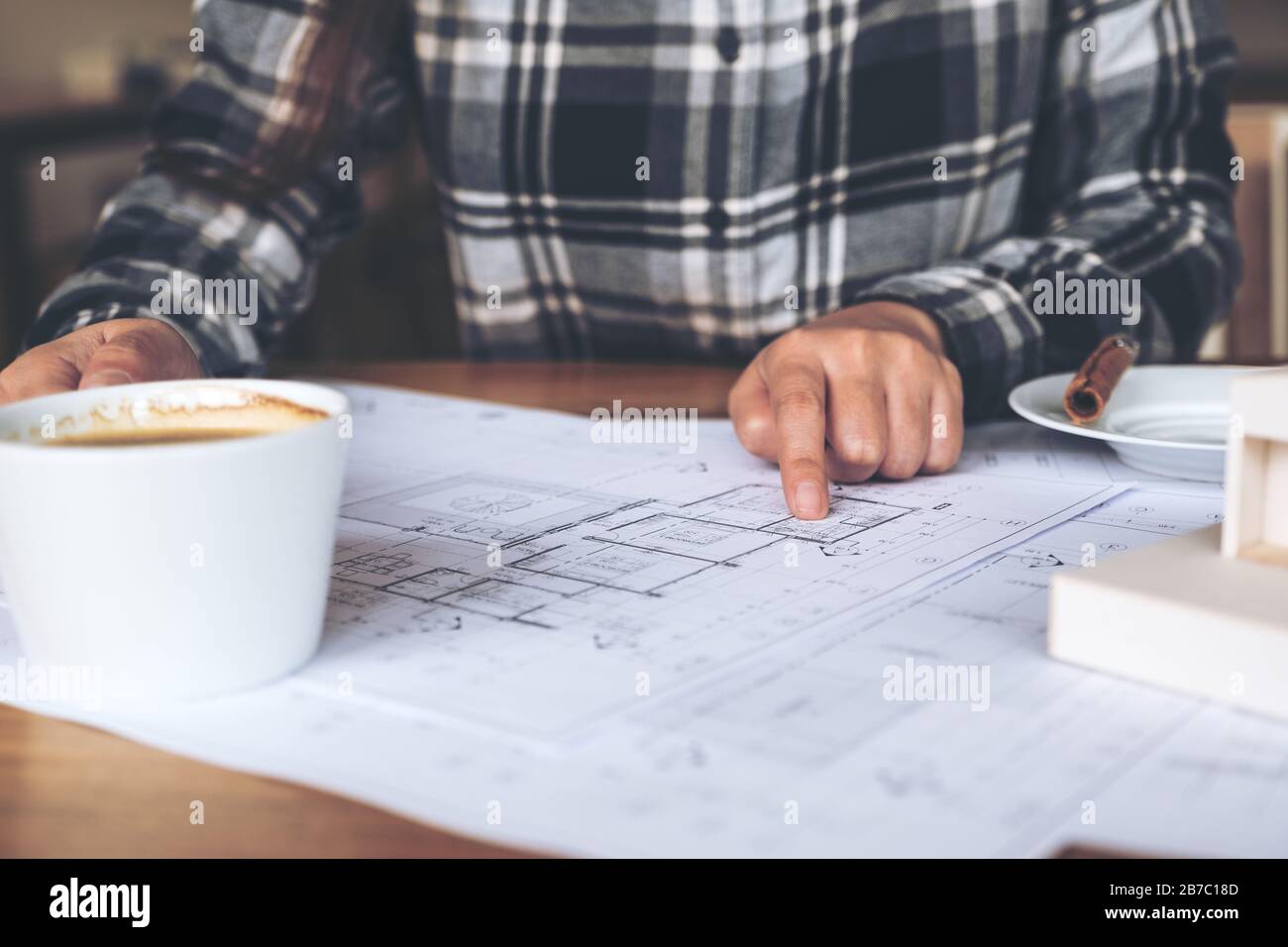 An architect working on an architecture model with shop drawing paper