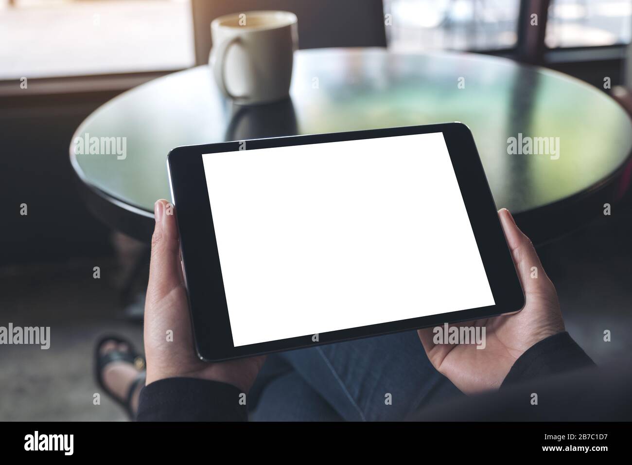 Mockup image of hands holding black tablet pc with blank white screen ...