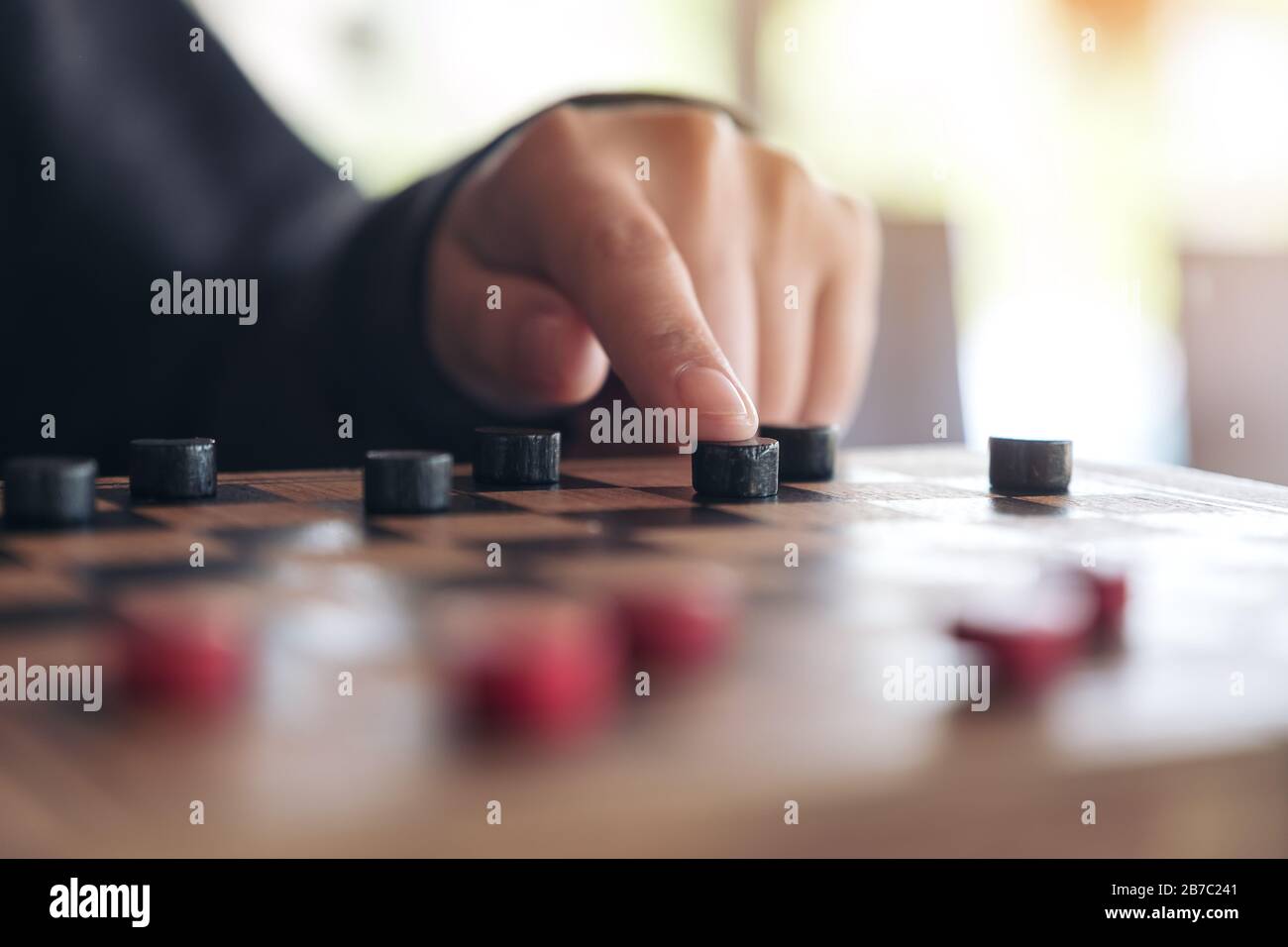 Closeup image of people playing and moving checkers in a chessboard Stock Photo Alamy