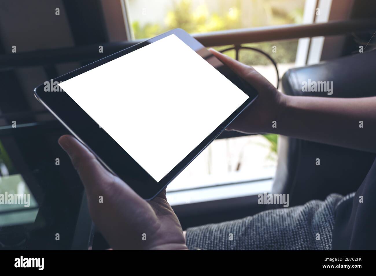 Mockup image of hands holding black tablet pc with white blank screen ...