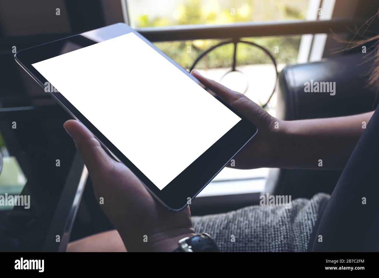 Mockup image of hands holding black tablet pc with white blank screen ...