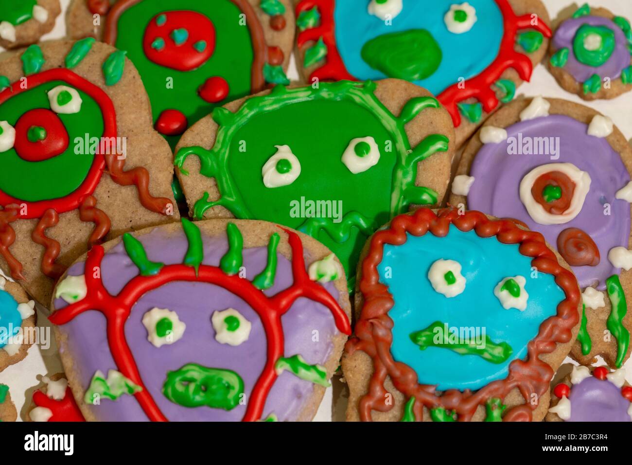 Cookies frosted with red, green, purple and blue, decorated like germs, bacteria, or viruses. Stock Photo