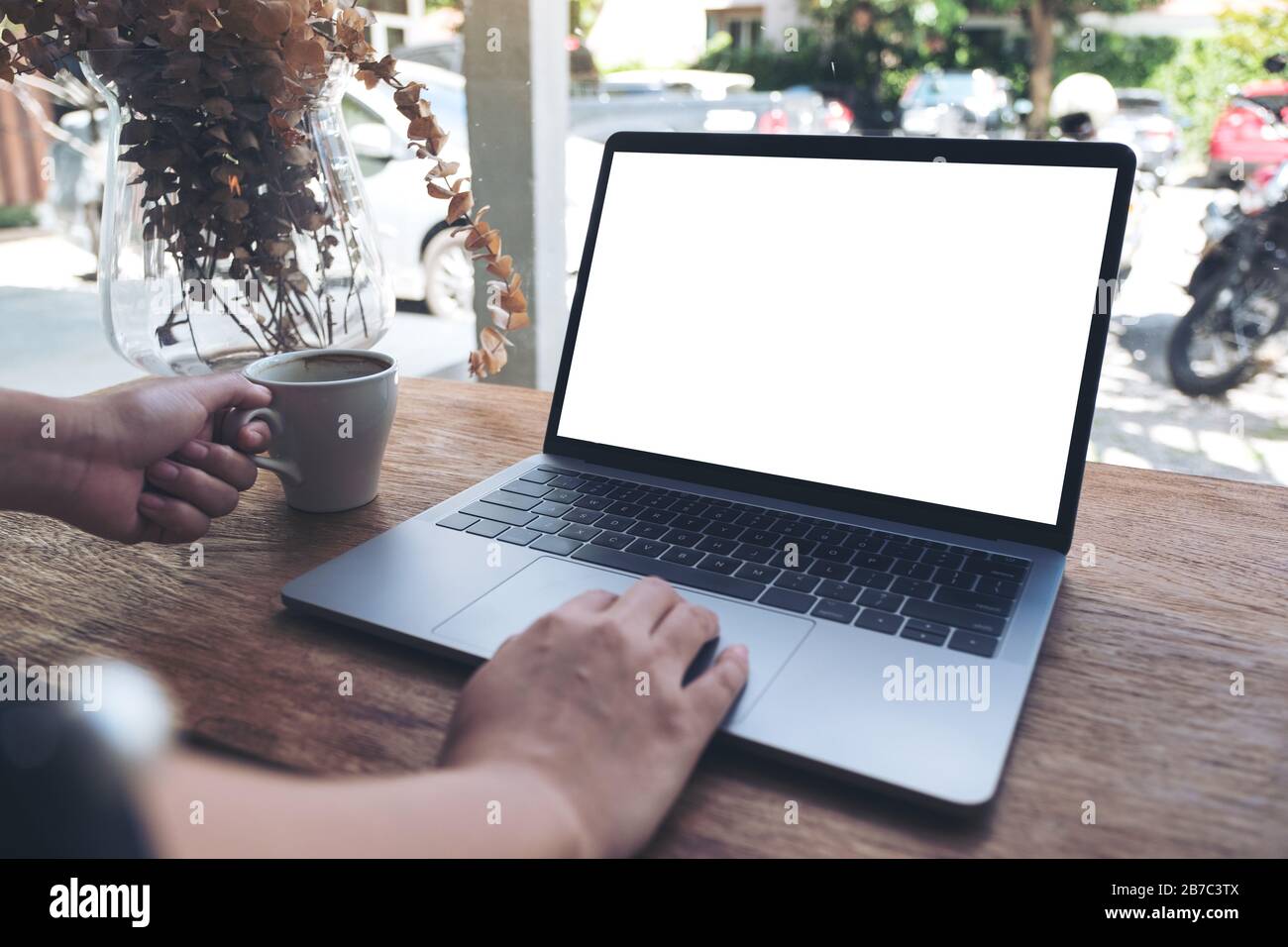 Mockup image of a woman using laptop with blank white desktop screen ...