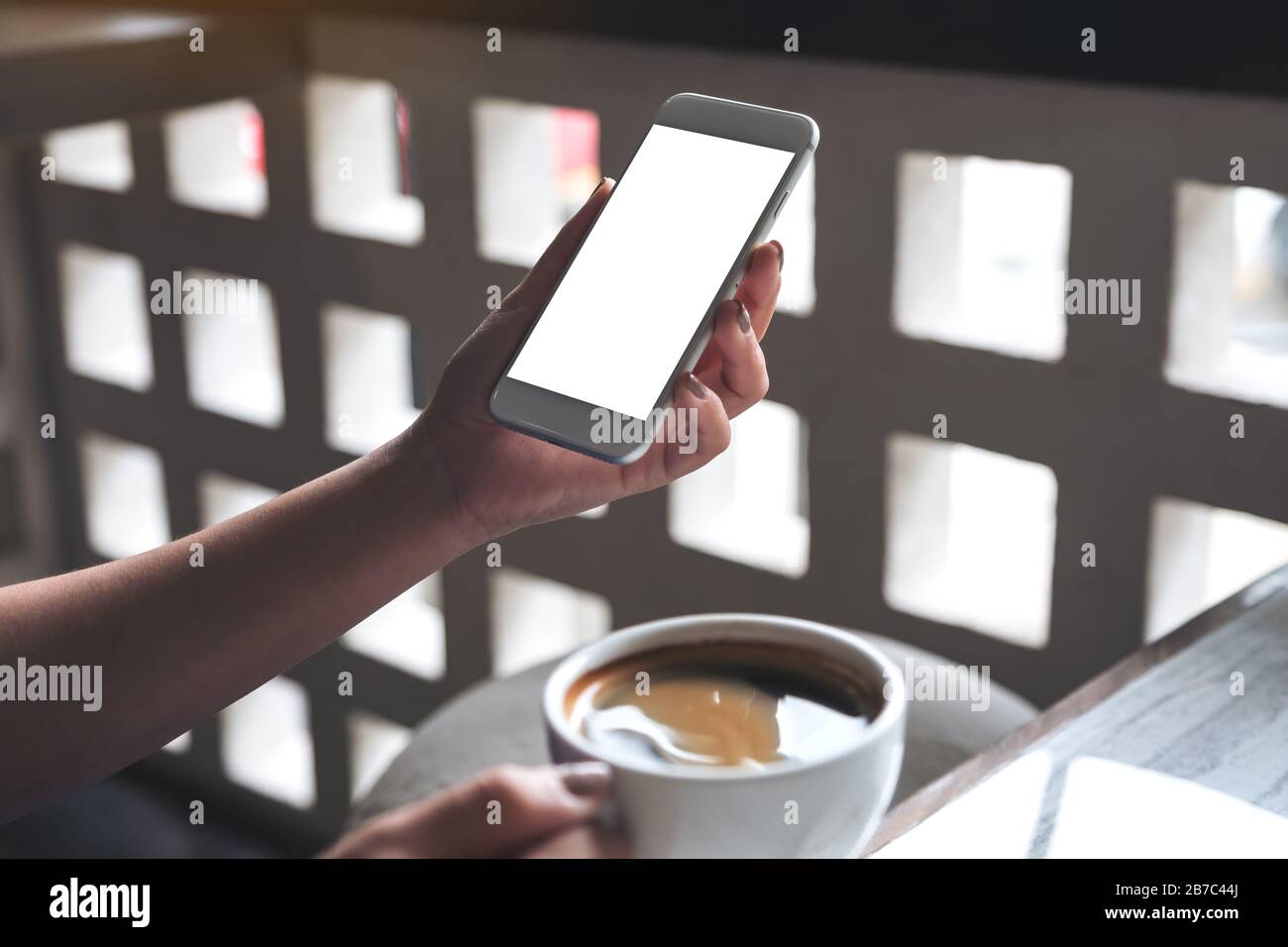 Mockup image of a woman's hand holding white mobile phone with blank ...