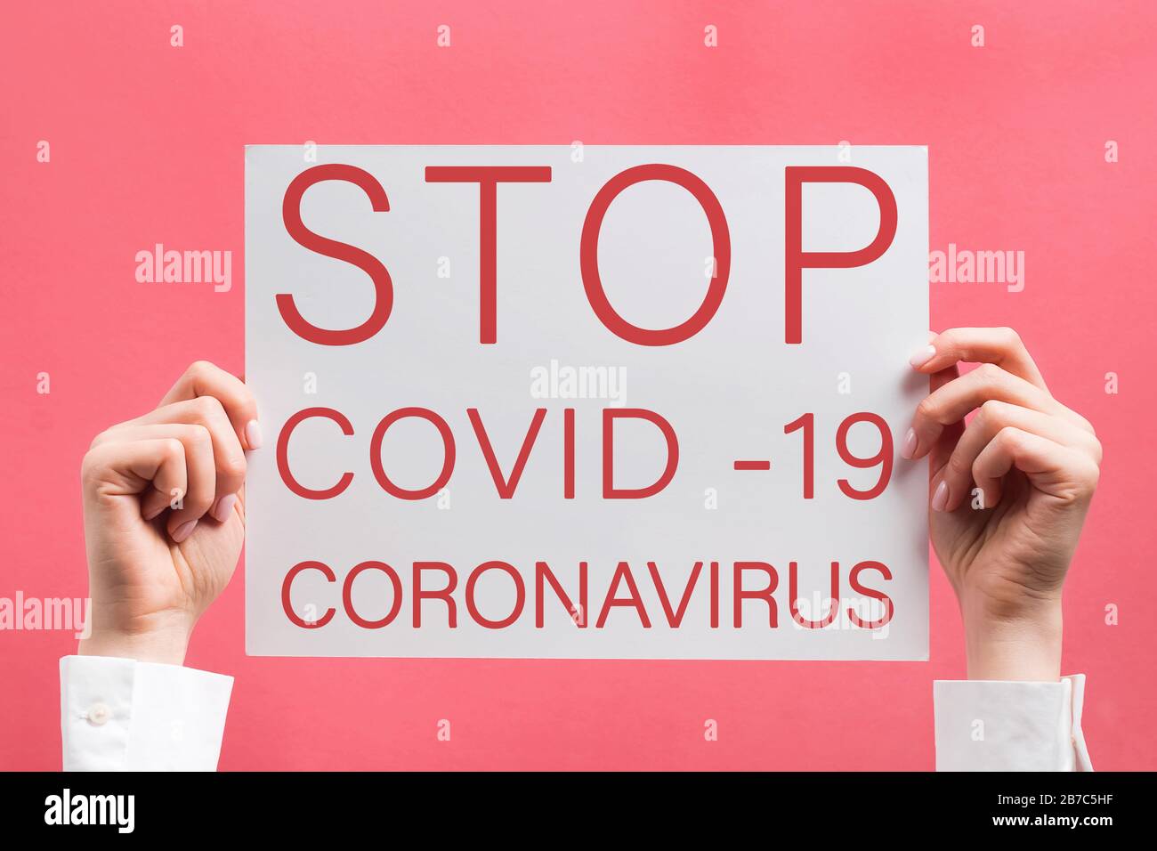 Woman's hands holding poster with text Stop Coronavirus. Stock Photo