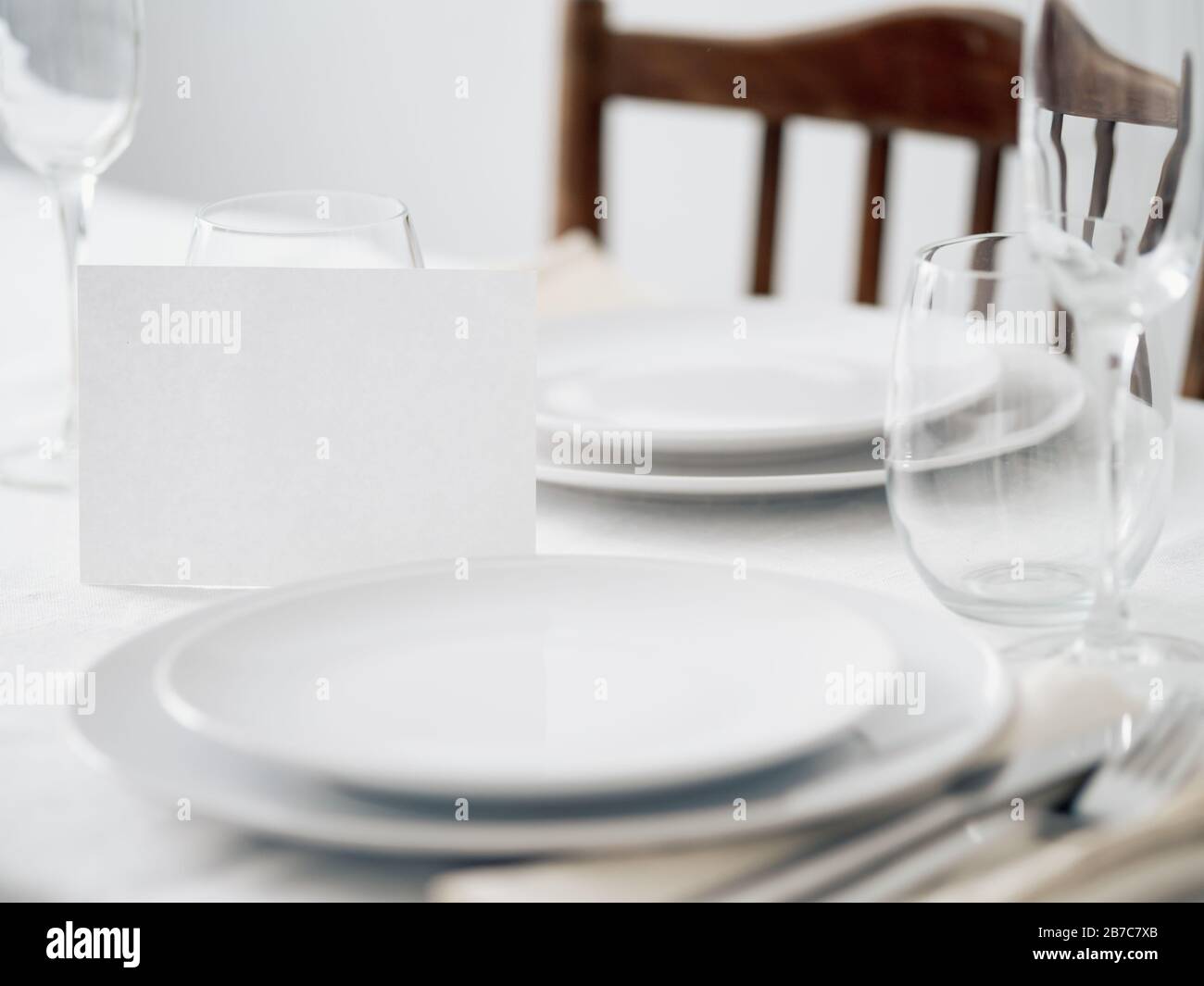 Beautiful table setting in white colors. Empty white plates. Set table for romantic dinner for two at home Stock Photo