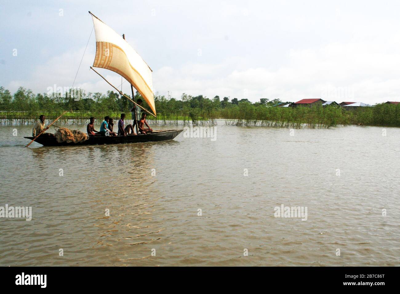 A traditional boat with sail in brahmaputra river in Gaibandha, Bangladesh.  Due to improved mechanical system, manual boat is very rare. Stock Photo