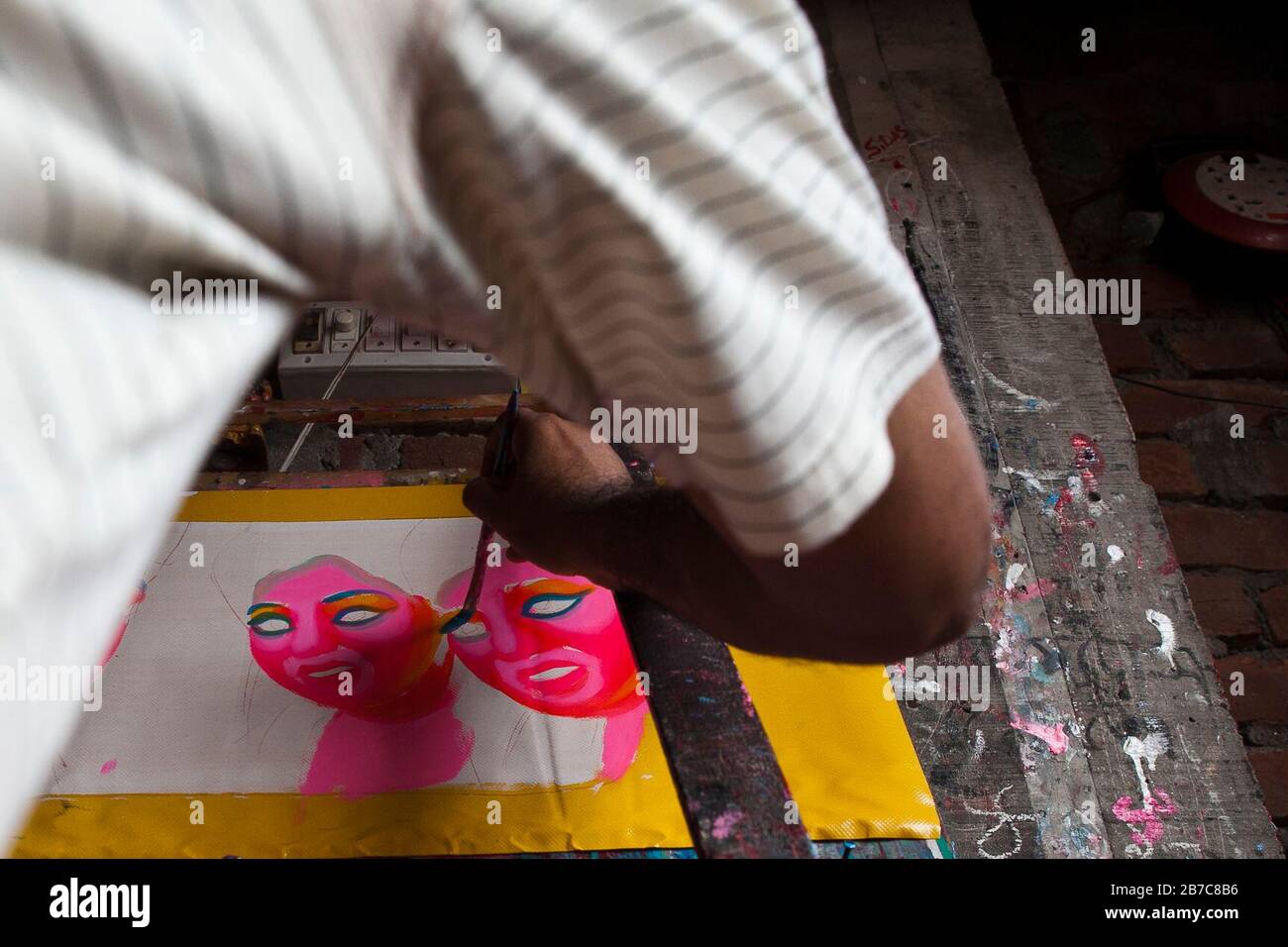 Proshanto Kumar Das, son of Raj Kumar Das, best known as RK Das, one of the first generation rickshaw artists in Bangladesh, is busy in painting a rickshaw art at his studio in capital Dhaka, on May 3, 2012. The rickshaw art is a form of pop art that depicts our urban culture and folklore of Bangladesh. Rickshaws were first introduced in Bangladesh in the 1930s from Japan, where the three-wheeled vehicles were known as 'nintaku'. The idea of decorating the leg-powered contraptions took off in Bangladesh the 1950s with the tradition following the simple yet colourful style then used by painters Stock Photo