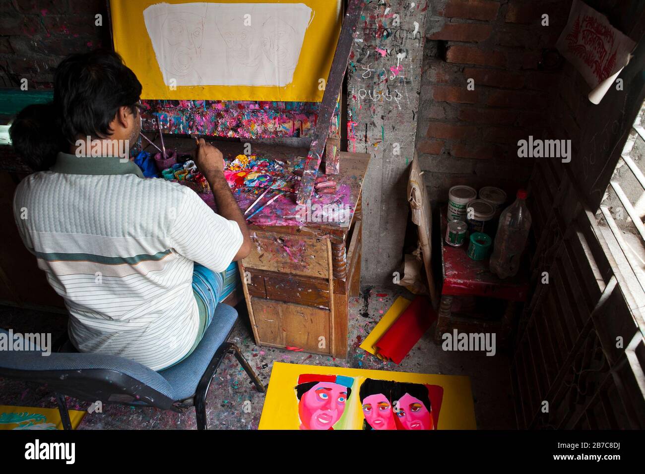 Proshanto Kumar Das, son of Raj Kumar Das, best known as RK Das, one of the first generation rickshaw artists in Bangladesh, is busy in painting a rickshaw art at his studio in capital Dhaka, on May 3, 2012. The rickshaw art is a form of pop art that depicts our urban culture and folklore of Bangladesh. Rickshaws were first introduced in Bangladesh in the 1930s from Japan, where the three-wheeled vehicles were known as 'nintaku'. The idea of decorating the leg-powered contraptions took off in Bangladesh the 1950s with the tradition following the simple yet colourful style then used by painters Stock Photo