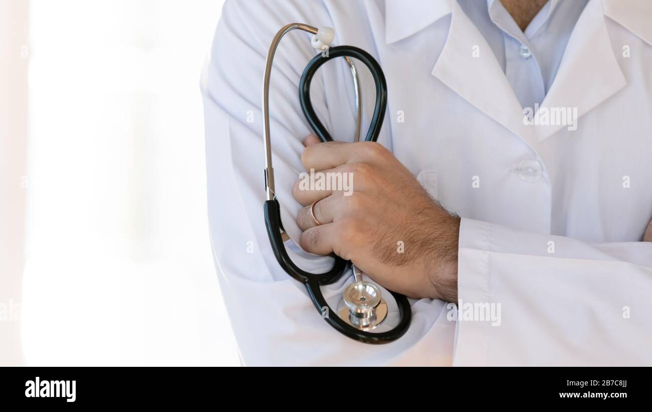 Male doctor in white coat uniform holding stethoscope Stock Photo - Alamy