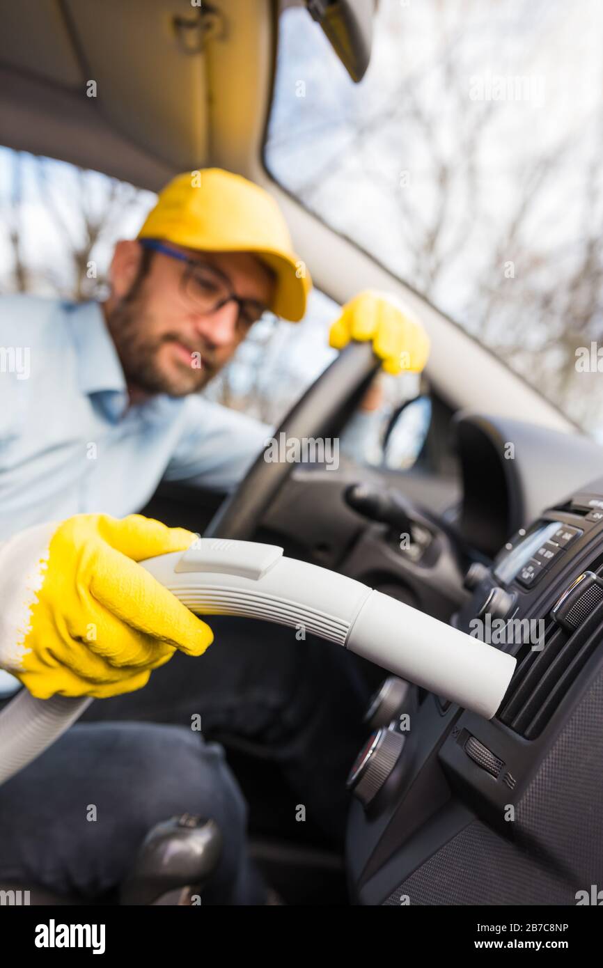 Professional handyman vacuuming car interior by using vacuum cleaner Stock Photo Alamy