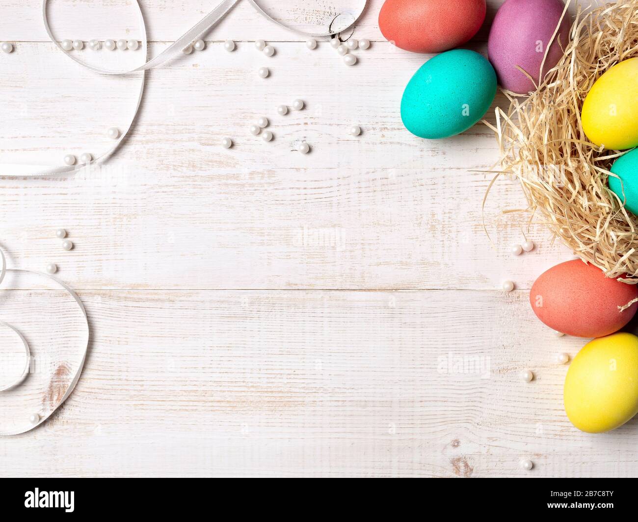 Easter concept. Colorful eggs on white wooden background with copy space for text or design. Top down view or flat lay Stock Photo