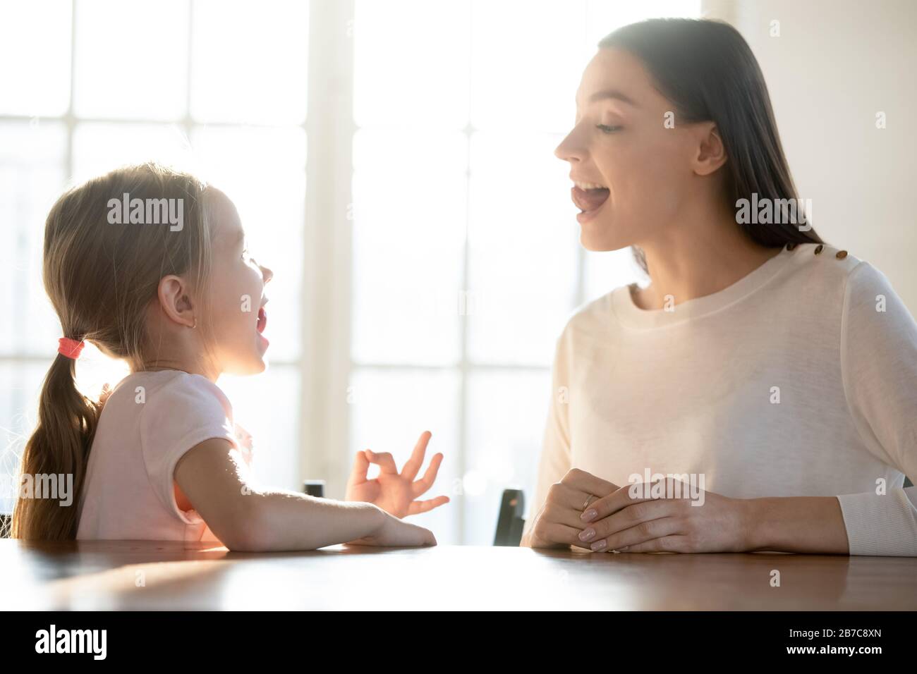 Female professional help small kid with speech difficulties. Stock Photo