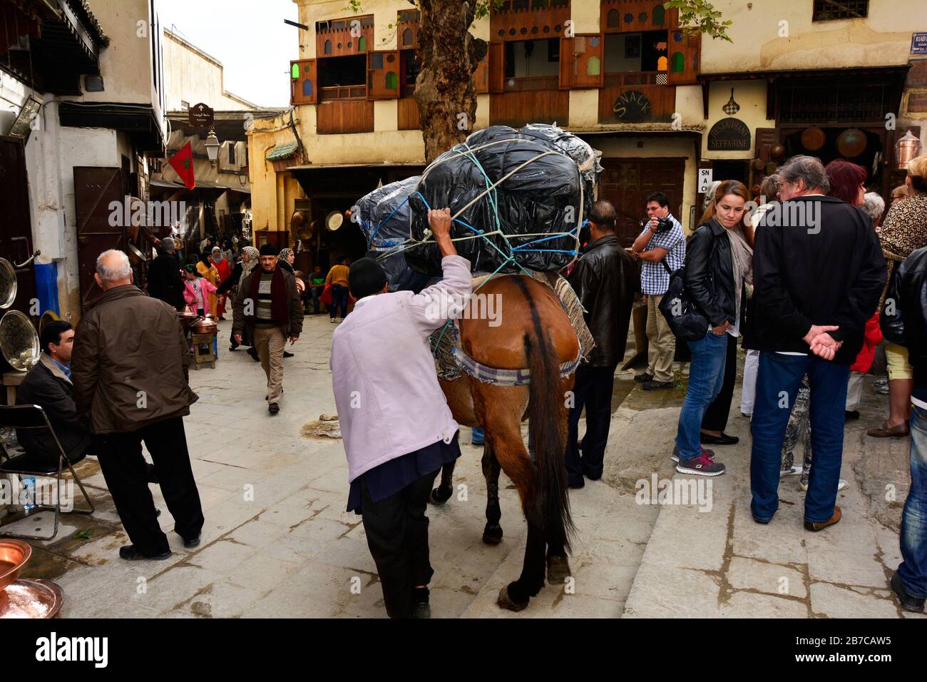 Fez, Morocco - November 20, 2014: Unidentified people and man with horse in narrow street in the souk of Fez Stock Photo