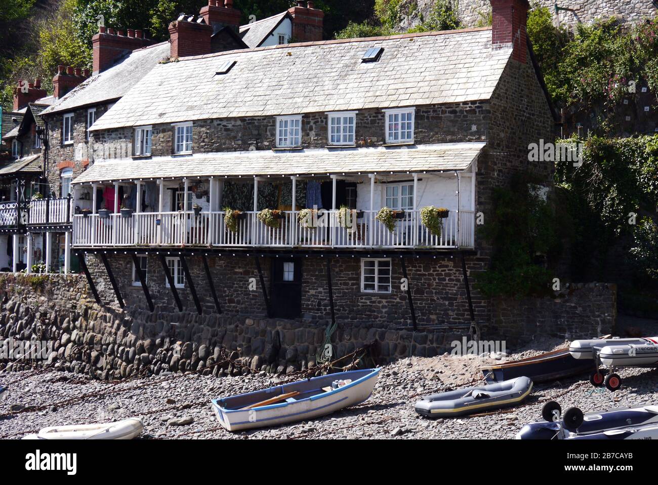Tied up Boats in the Harbour by a Row of Old Fishermen Cottages in the Fishing Village of Clovelly on the South West Coast Path, North Devon. England. Stock Photo