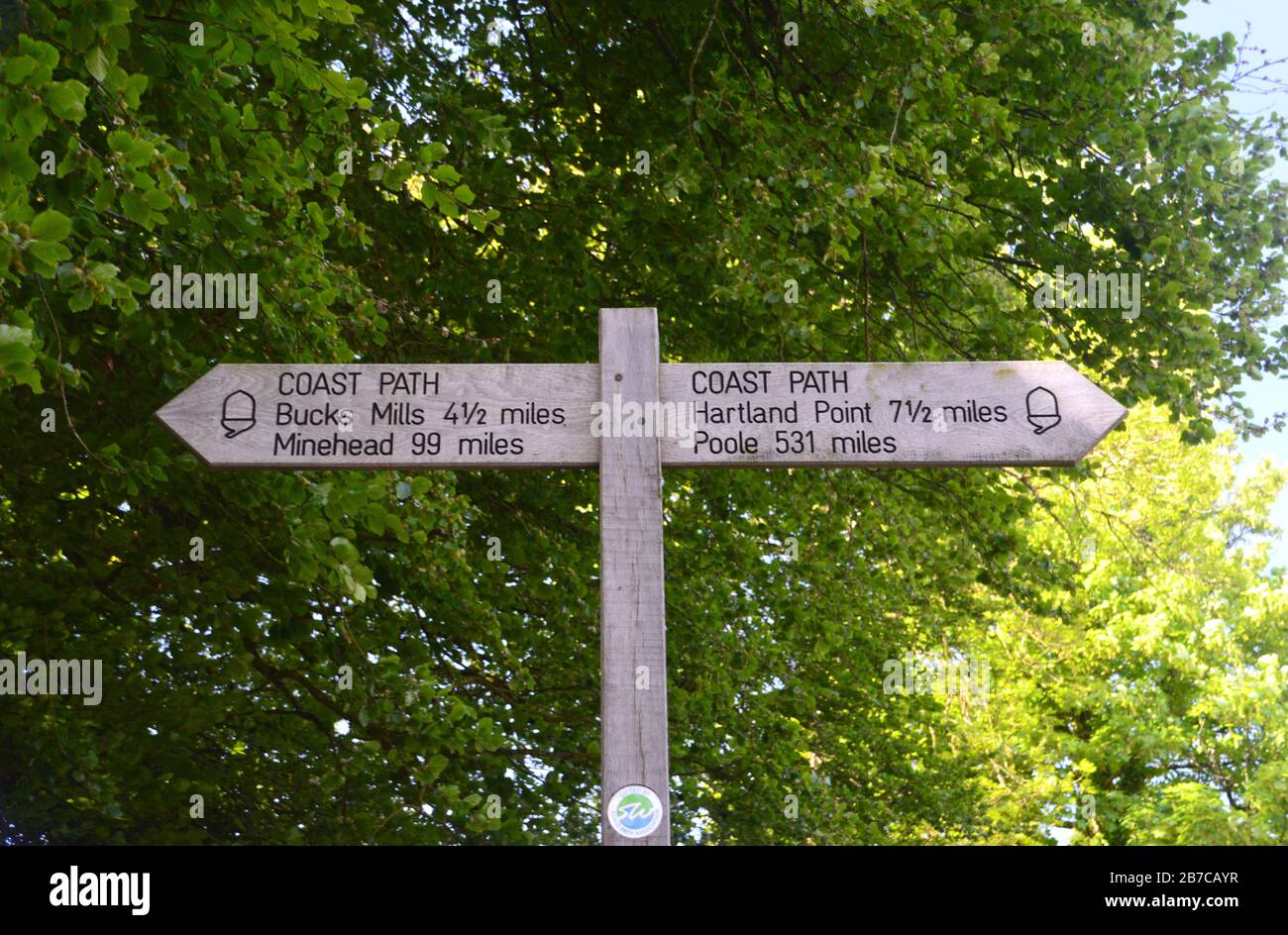 Wooden Signpost for Buck's Mills/Minehead & Hartland Point/Poole in Clovelly on the South West Coast Path, North Devon. England, UK. Stock Photo