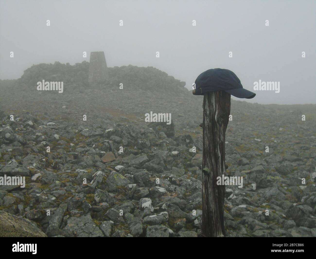Old Wooded Post & Peaked Cap by the Stone Shelter and Trig Point  on the Summit of the Scottish Mountain Corbett 'Morven' near Ballater, Deeside. Stock Photo