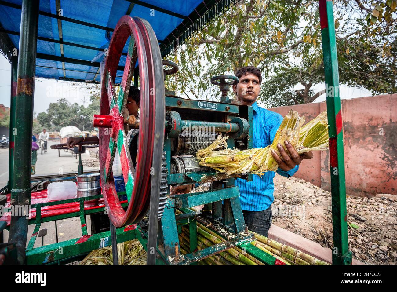 AGRA, UTTAR PRADESH, INDIA - FEBUARY 24, 2015: Young Indian man making sugarcane juice which is very famous in India Stock Photo