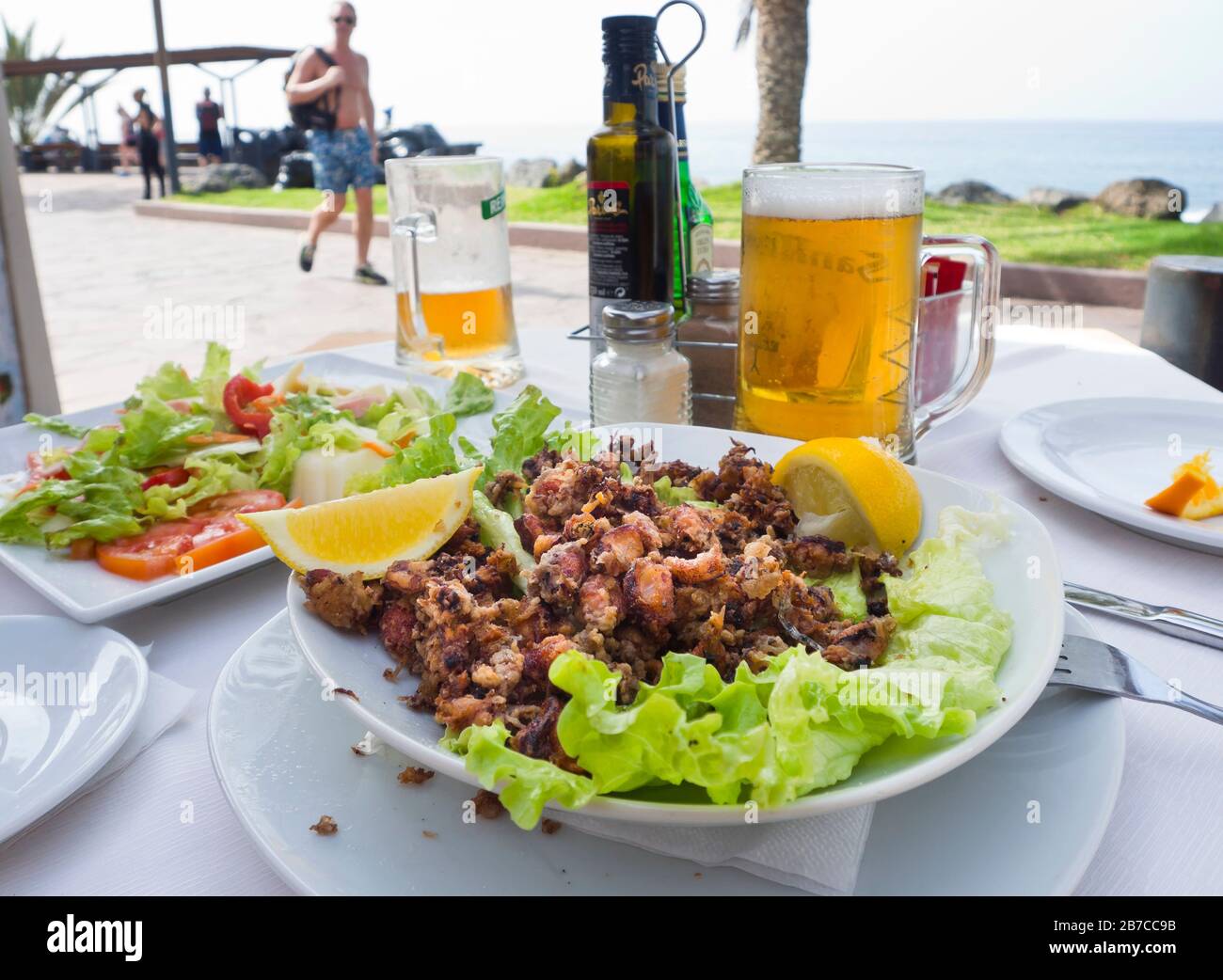 Chopitos, a tasty fry up dish of tiny Sepia orbignyana served with a cold beer on the seafront promenade in Costa Adeje, Tenerife Canary Islands Spain Stock Photo