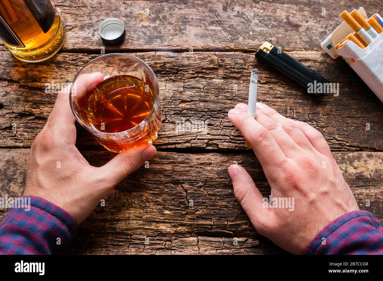 whisky and cigarette man holding a glass of whiskey and smoking a cigarette Stock Photo