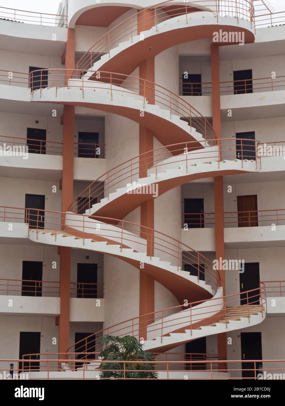 Architecture in red and white, an outdoors spiral staircase on a building in the tourist resort of Los Christians, Tenerife, Canary Islands Spain Stock Photo