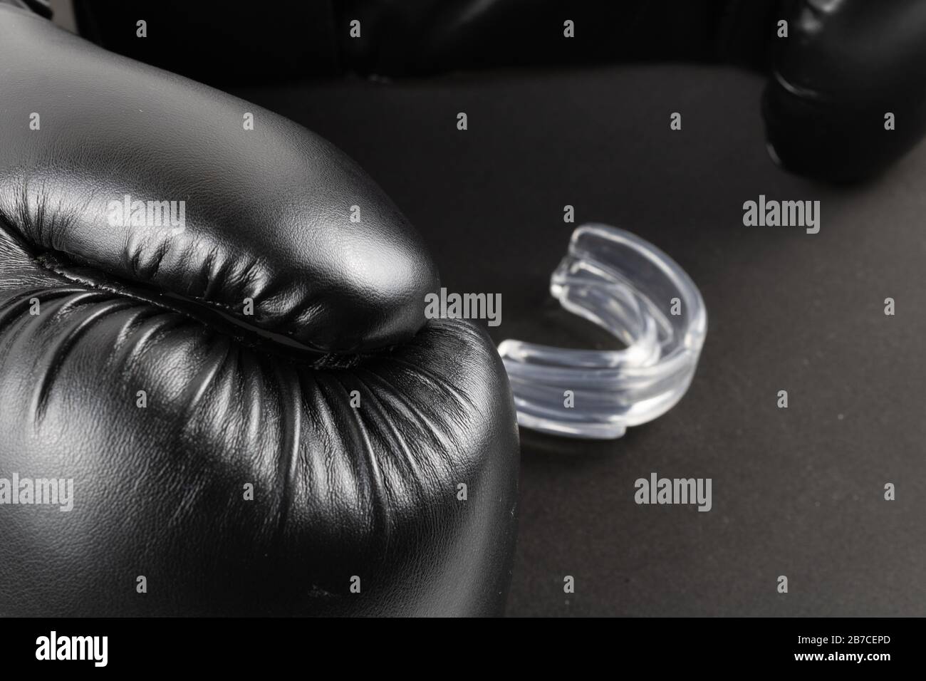 Boxing gloves and a mouth guard on a black background. product image Stock Photo