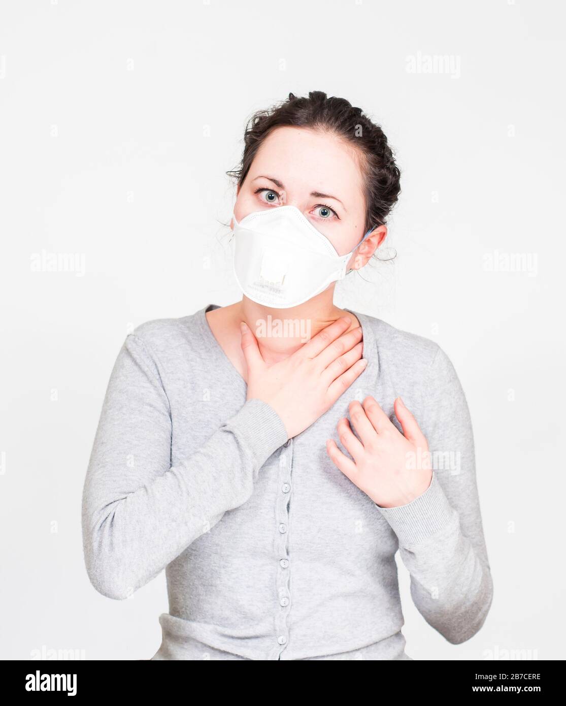 caucasian brunette woman in protective medical mask on face protection for spreading of disease virus SARS-CoV-2, Coronavirus, COVID-19. white backgro Stock Photo