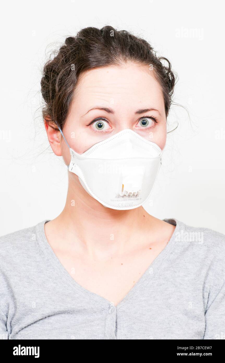 caucasian brunette woman in protective medical mask on face protection for spreading of disease virus SARS-CoV-2, Coronavirus, COVID-19. white backgro Stock Photo