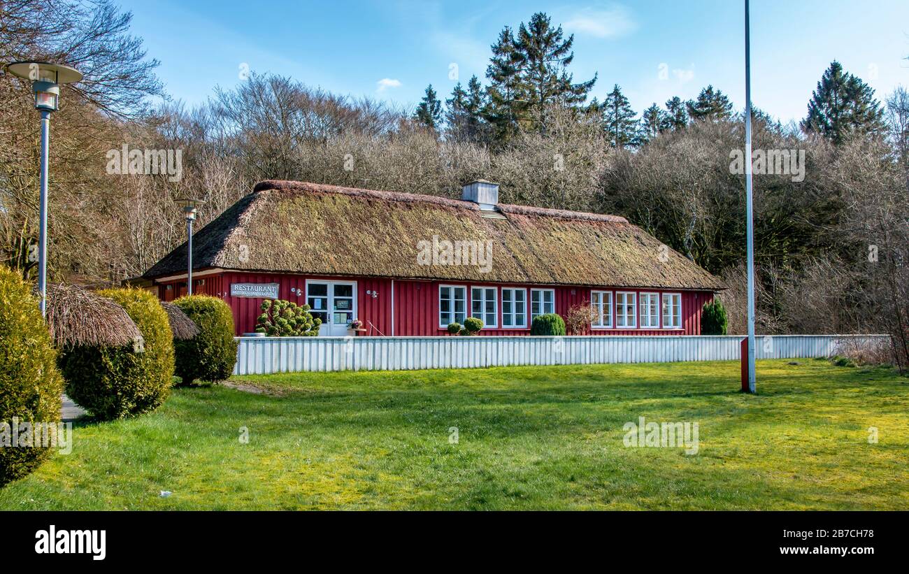 A nice restaurant made of wood with thatched roof. trees and forest in the  background and lawn in the foreground. Mosskov Pavilonen - an idyllic resta  Stock Photo - Alamy