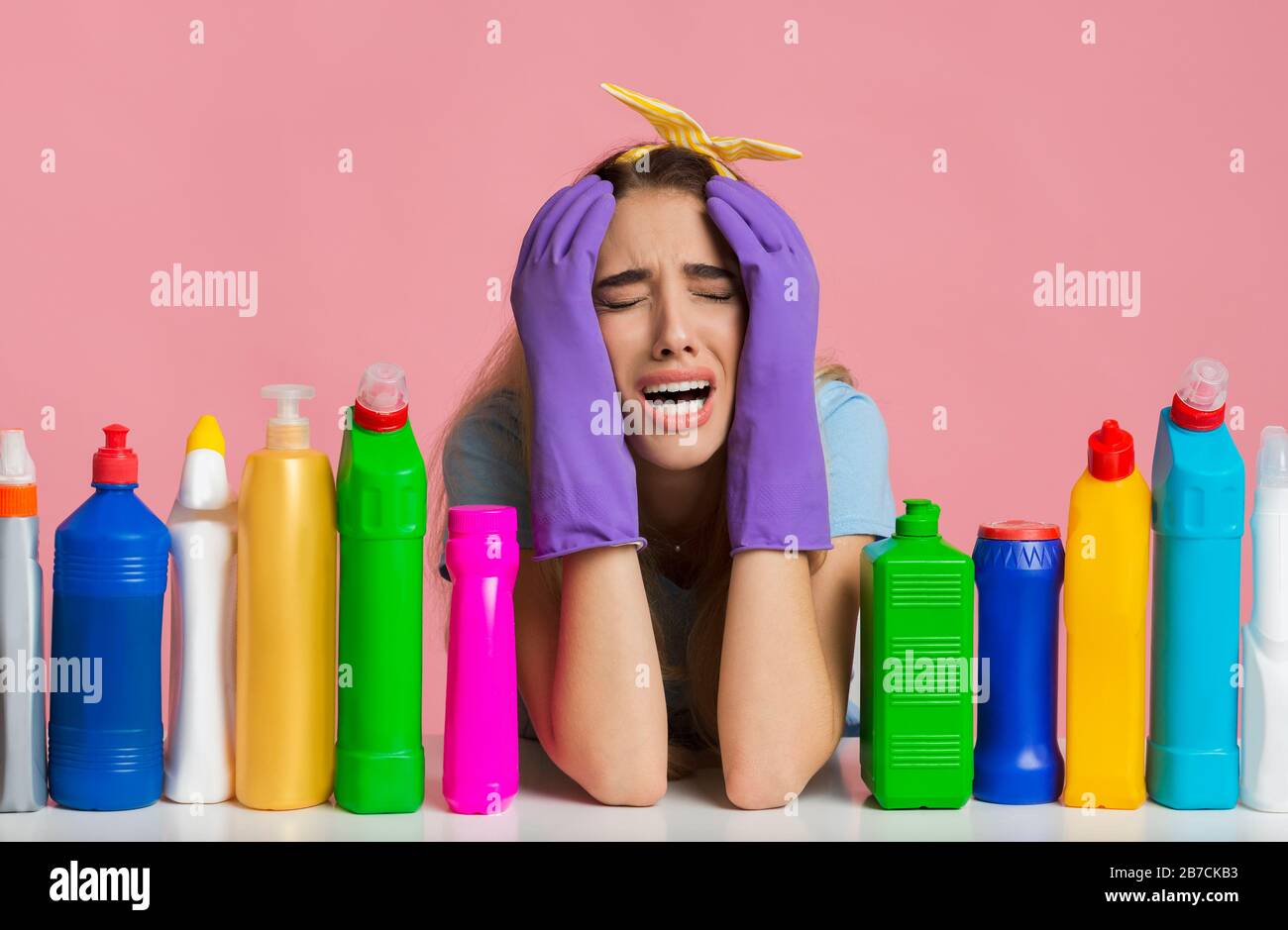 Young housewife crying by cleaning, near cleaning supplies Stock Photo