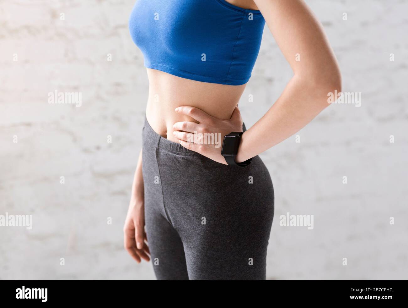Young slim woman with ealthy skin flat belly wears black cropped
