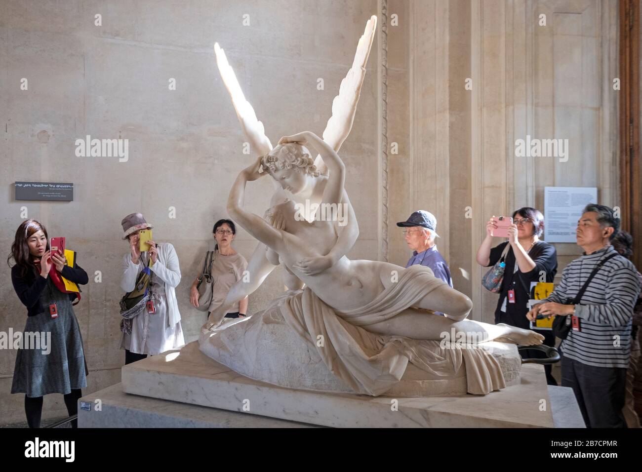 Asian tourists photographing the Psyche Revived by Cupid's Kiss by italian artist Antonio Canova at the Louvre Museum in Paris, France, Europe Stock Photo