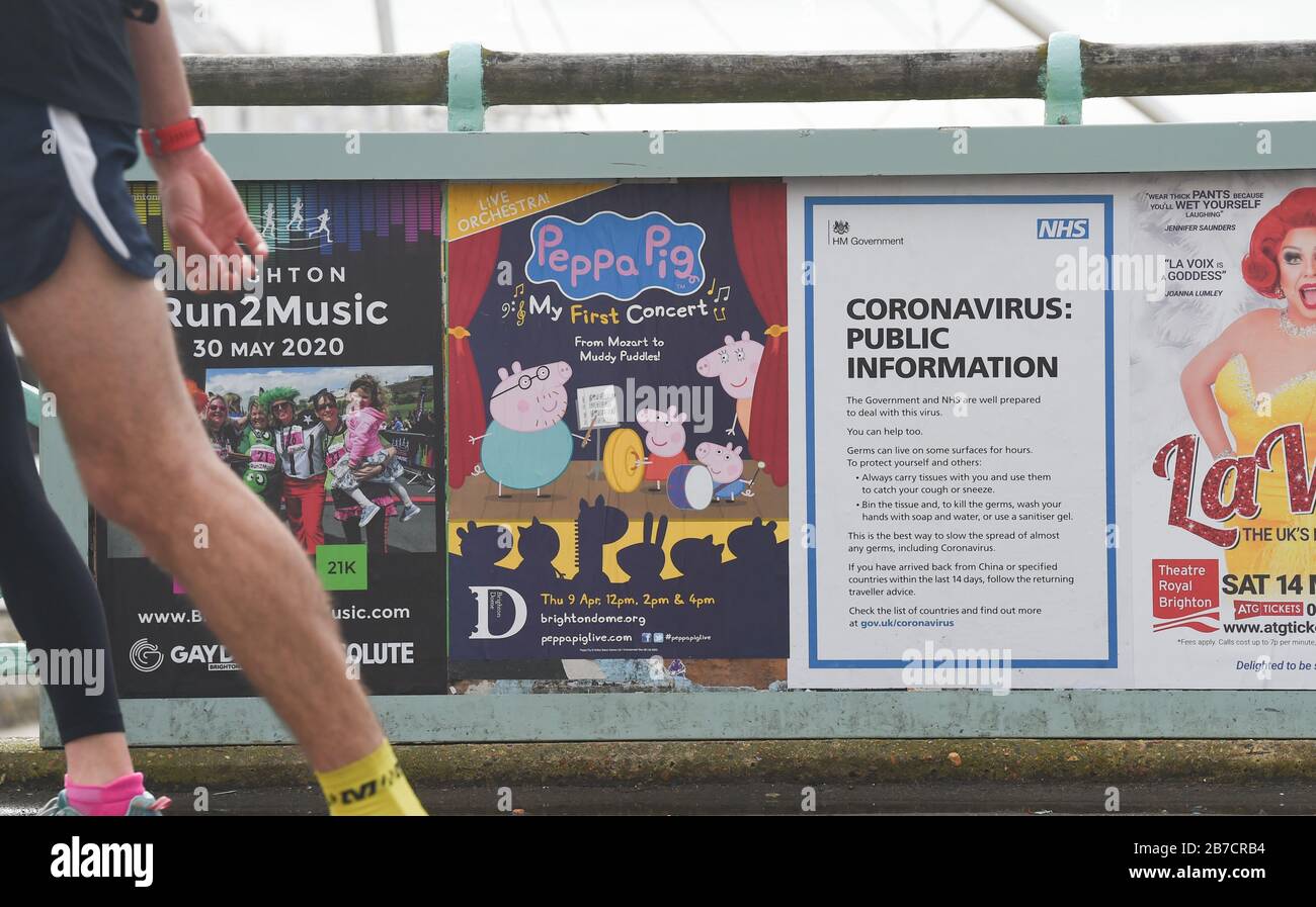 Brighton UK 15th March 2020 - An NHS Coronavirus public information poster  alongside a poster advertising a Peppa Pig show on Brighton seafront today  : Credit Simon Dack / Alamy Live News Stock Photo