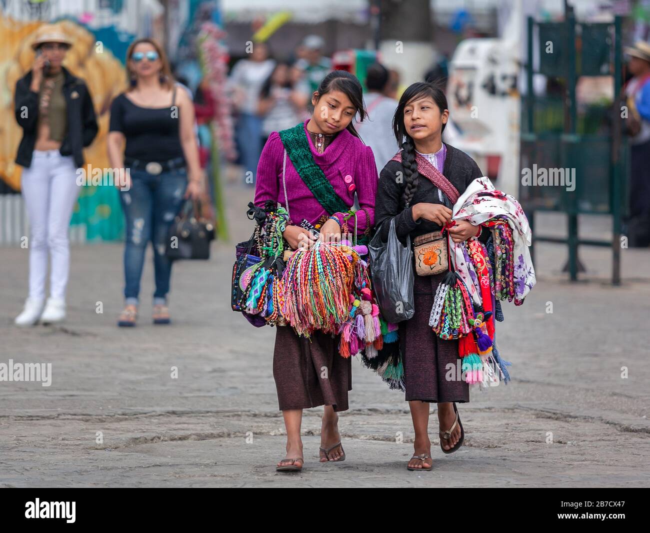 indigenous girls local vendors sell traditional colorful mayan textile on the street San Cristobal de las Casas, Mexico Stock Photo