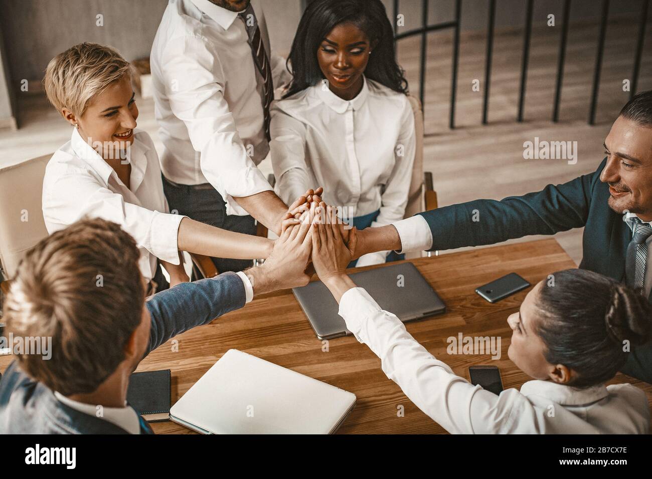 Colleagues Giving High-Five Celebrating Business Success Standing In Office  Stock Photo by ©Milkos 381522740