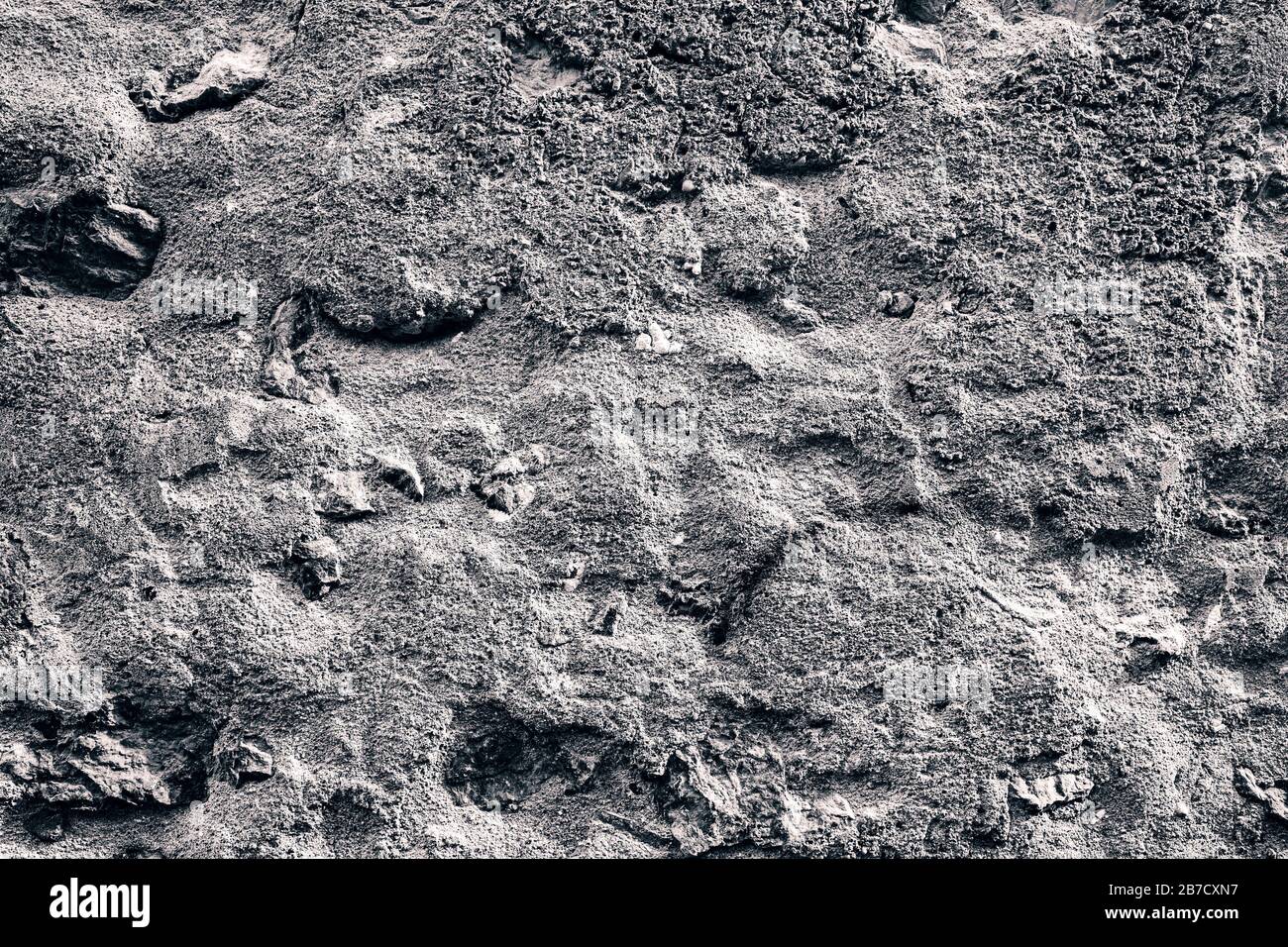 Uneven rough bubbly concrete wall, texture for background Stock Photo