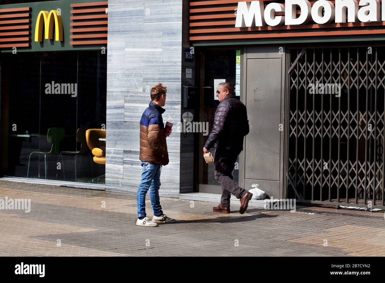 Beggar asking a passerby for change, Sagrada Familia, Barcelona. Stock Photo