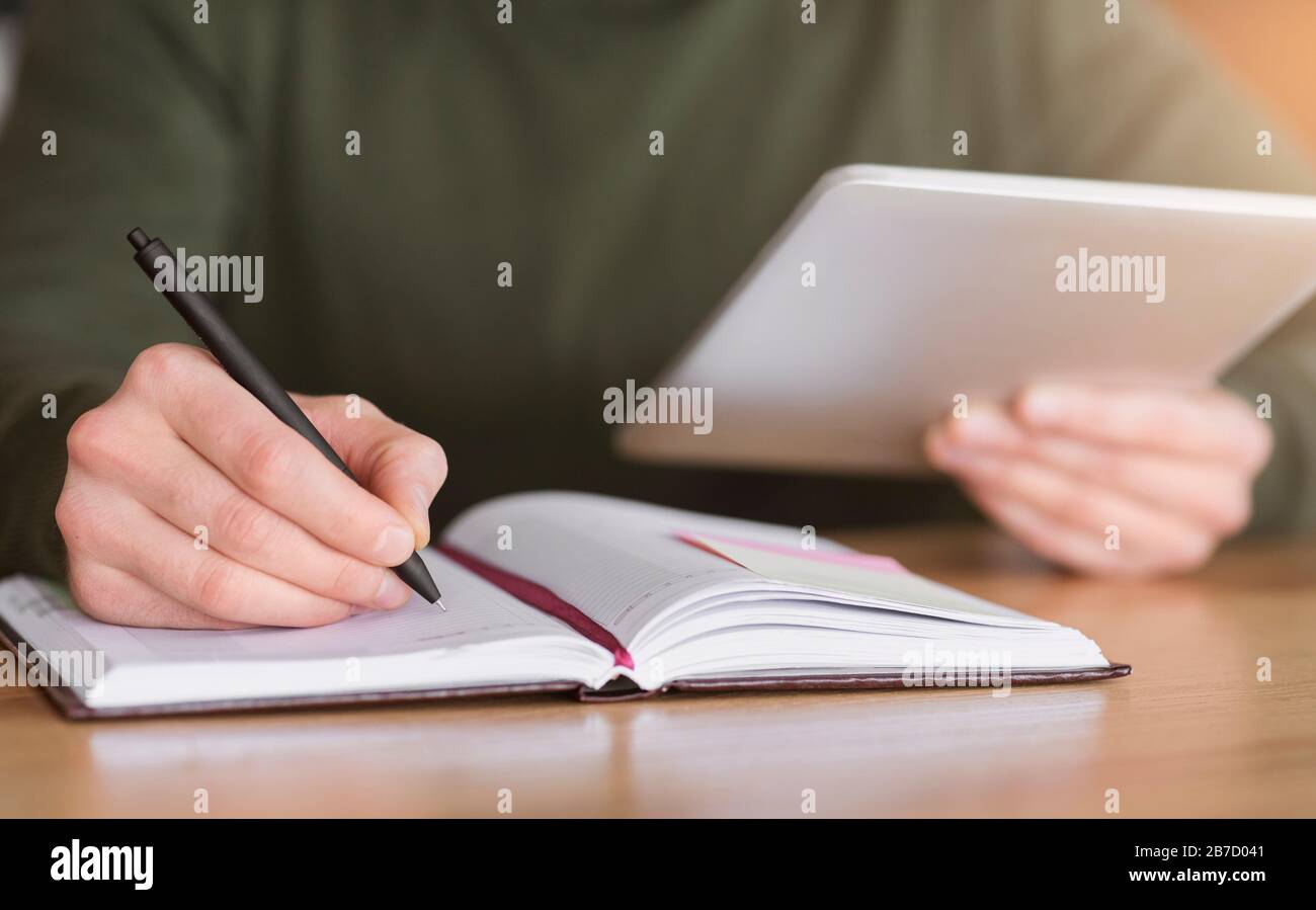 Man hands taking notes and holding digital tablet Stock Photo