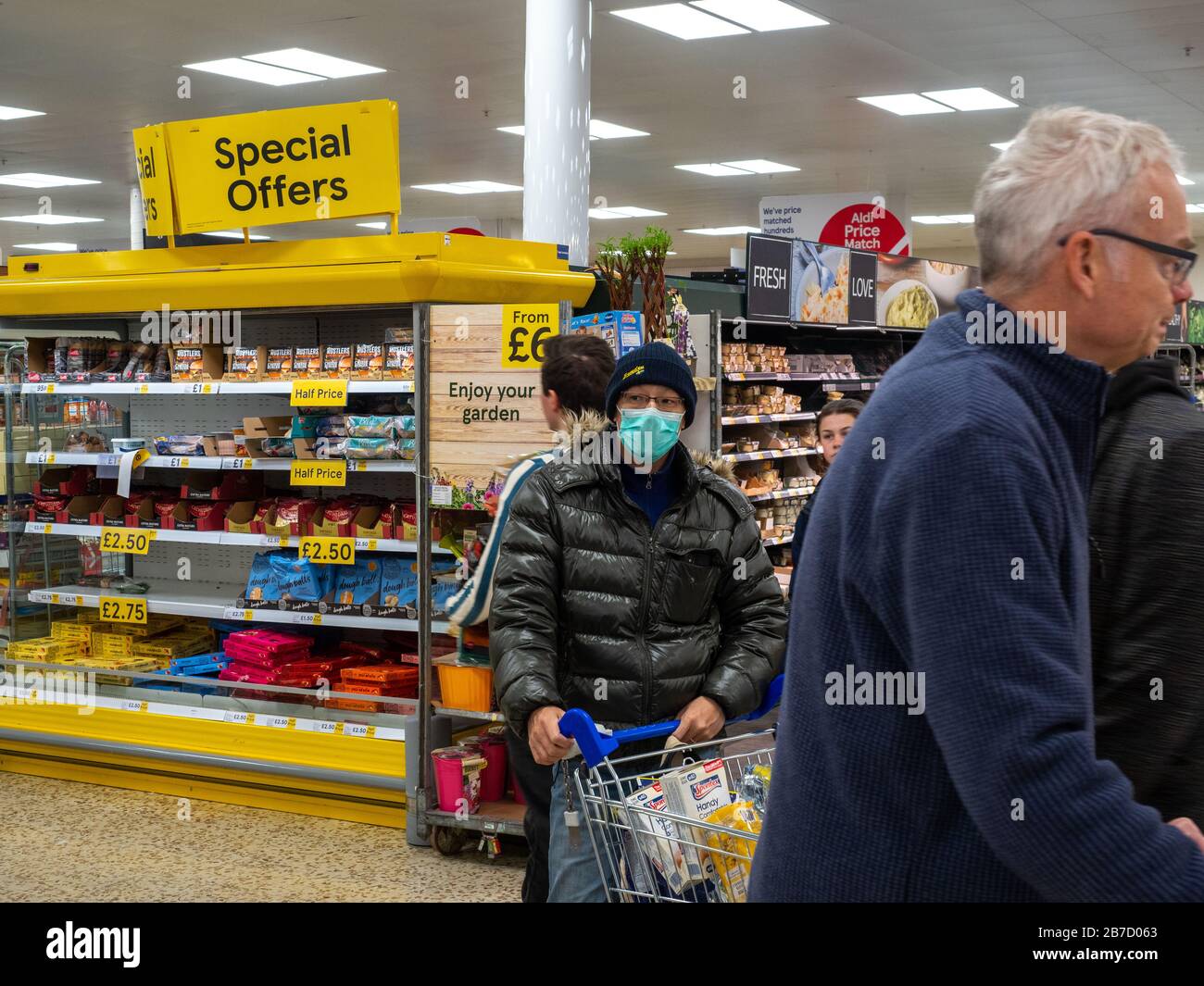 Shpper at Tesco Extra protect themselves from infection by wearing a