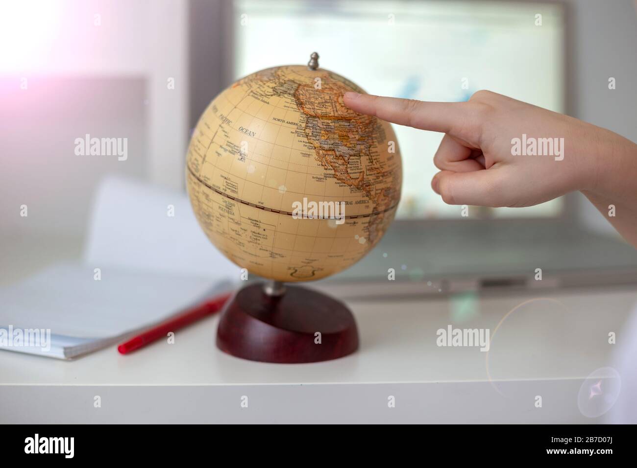 The Childs Hands Bring A Finger Across The Globe At A White