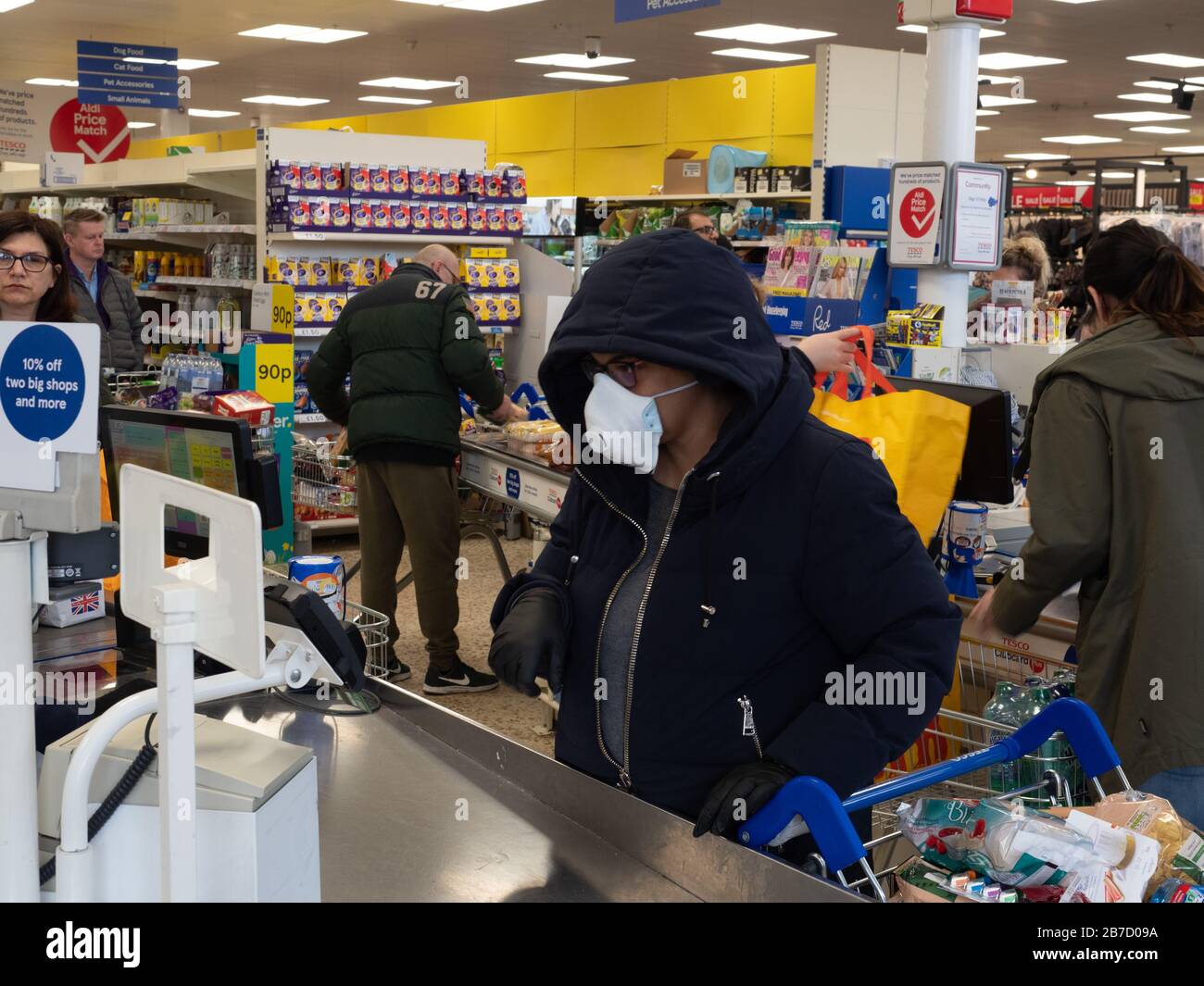 Shpper at Tesco Extra protect themselves from infection by wearing a