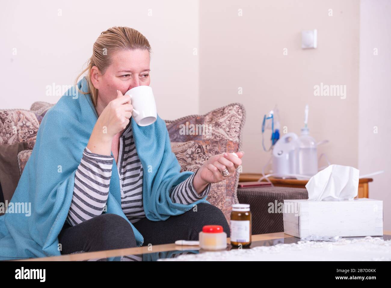 A very sick woman with temperature drinks warm tea Stock Photo Alamy
