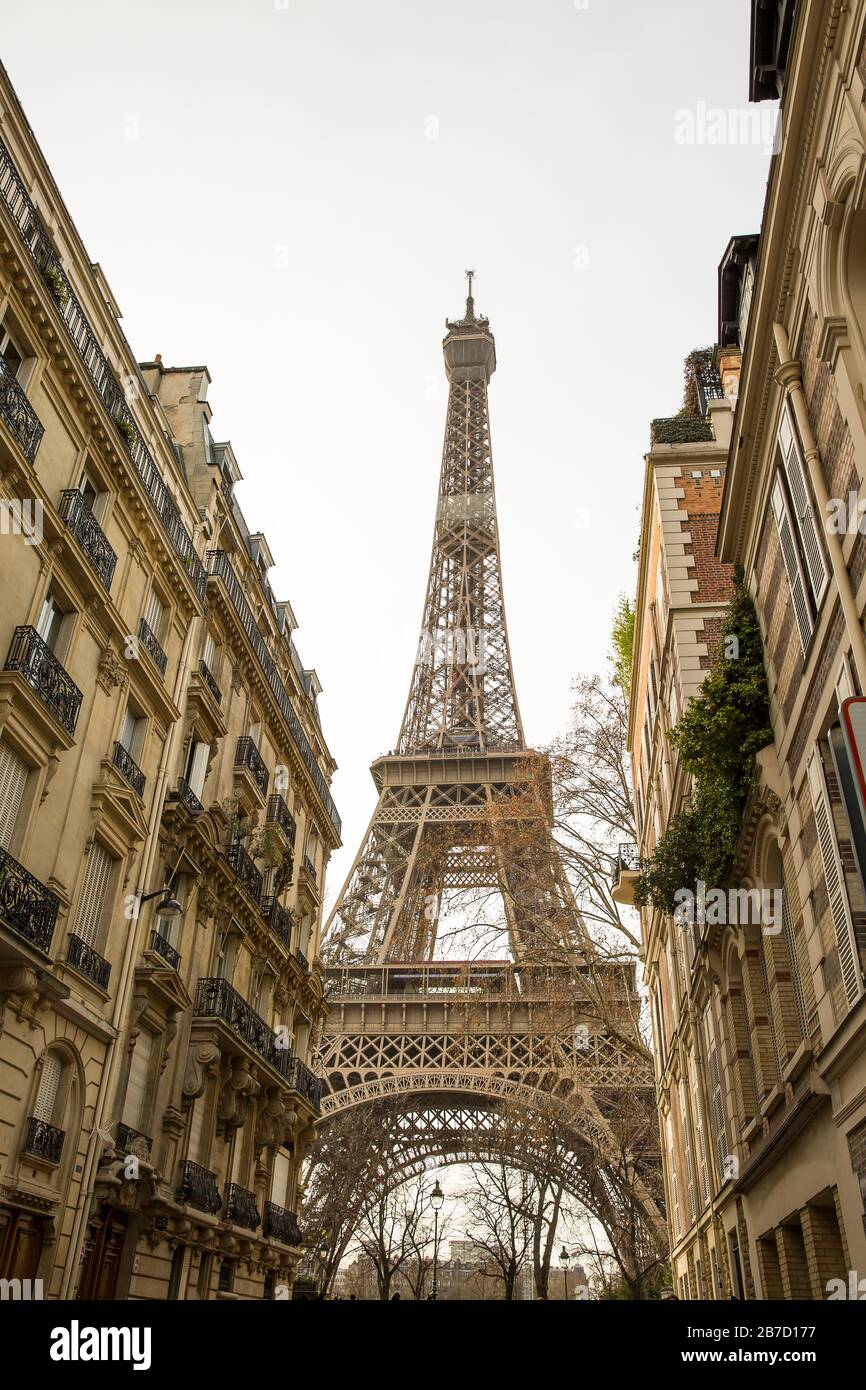 Small paris street with view on the famous paris eiffel tower on a cloudy rainy day. Stock Photo