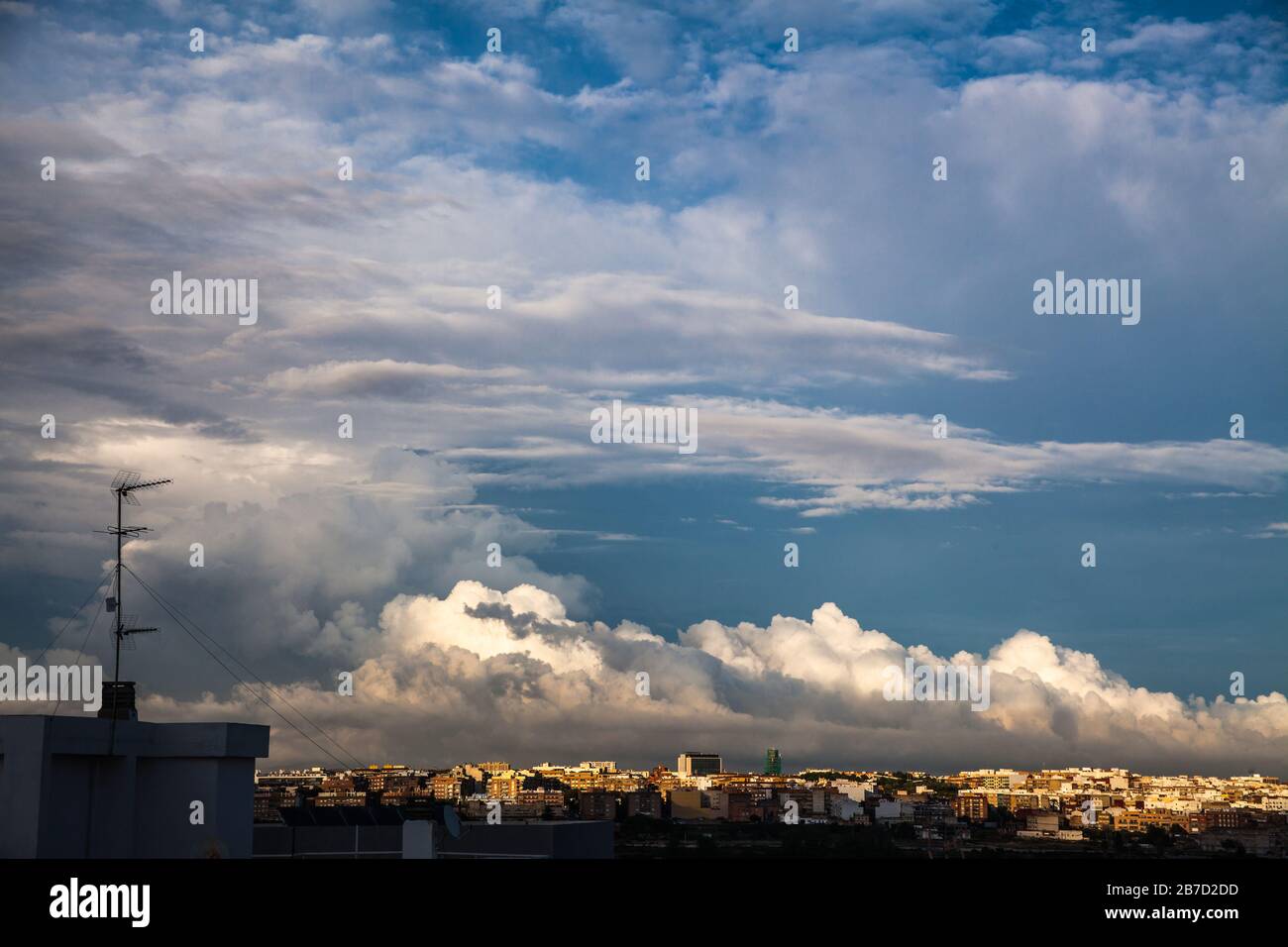 Storm clouds advance over the city and the antennae on the rooftops Stock Photo