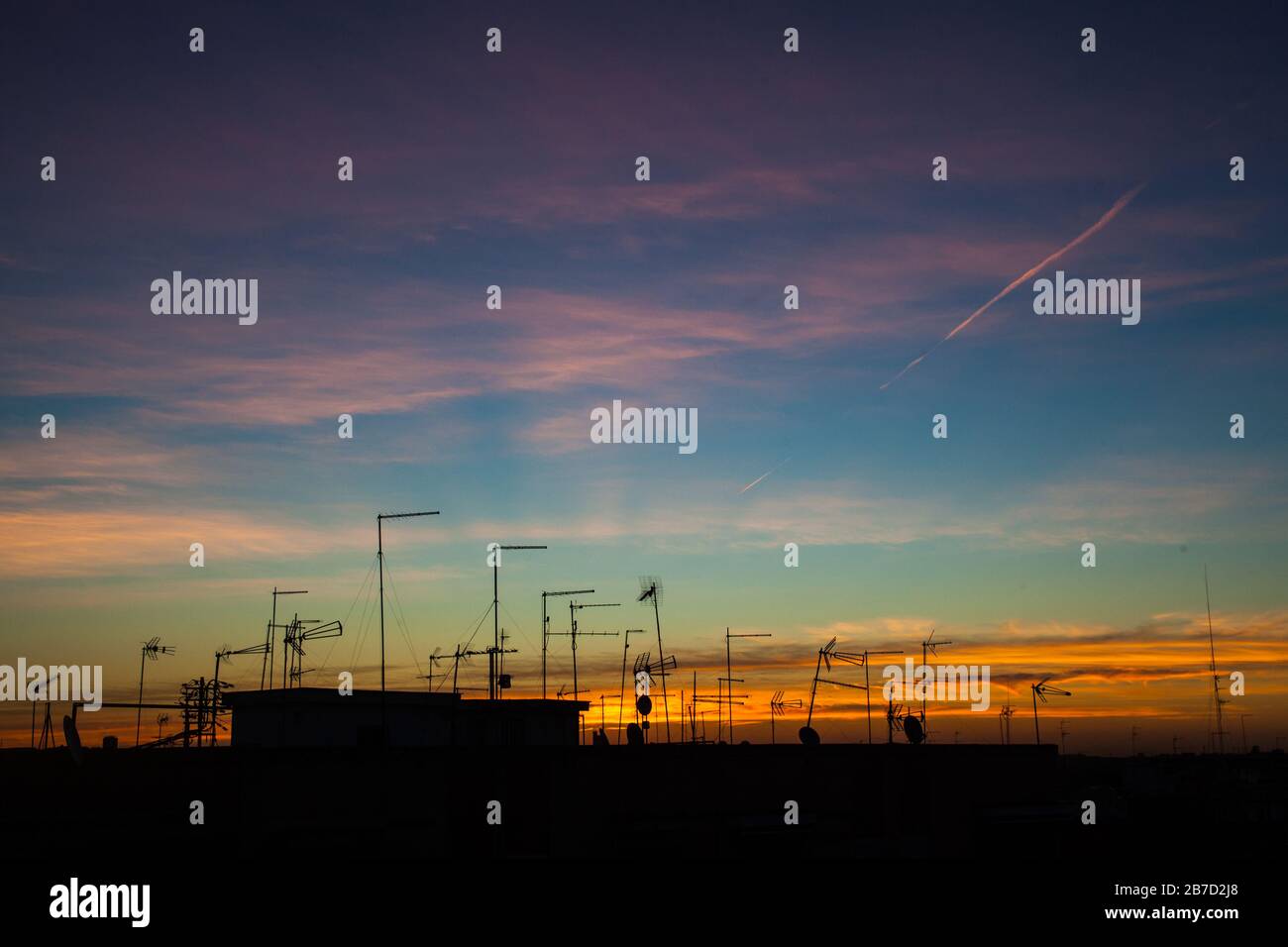 Sunrise in the city with silhouette of roofs and antennas Stock Photo