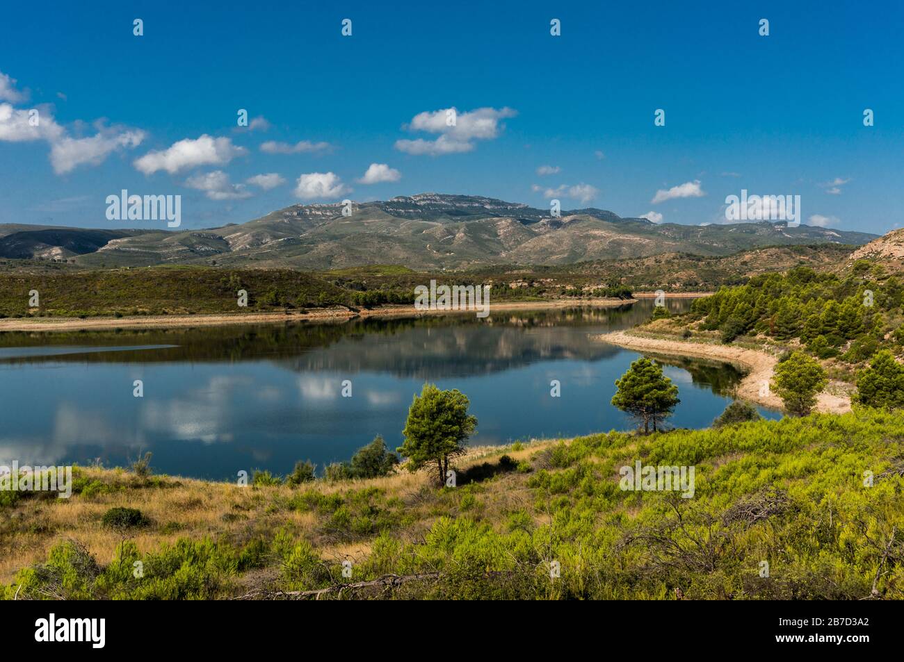 landscape of mountains with blue sky and clouds reflected in the water in Forata dam in Yátova (Valencia - Spain) Stock Photo