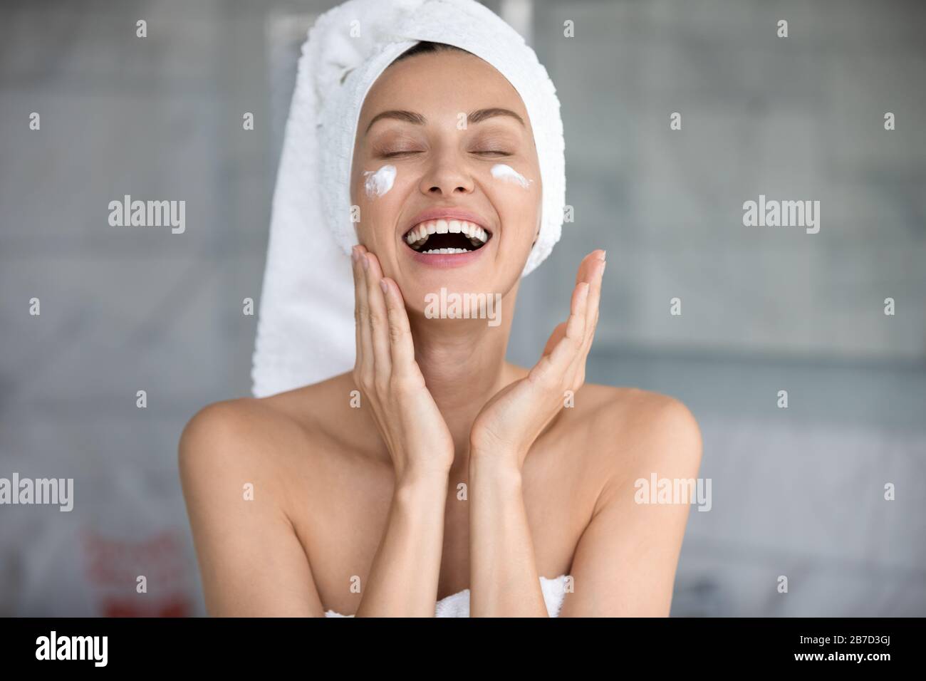 Joyful lady using professional skincare product alone in bathroom. Stock Photo